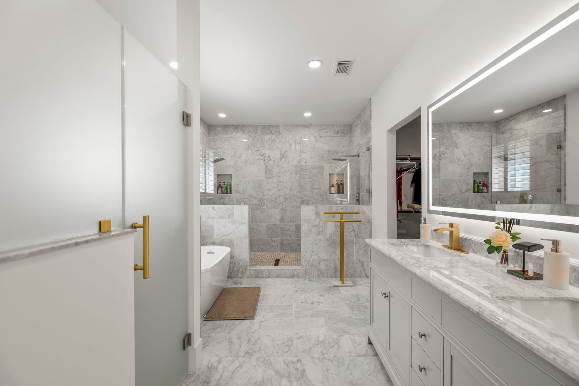 31219 Edgewater Drive, Magnolia, TX 77354 The primary bathroom features an extended vanity, a large mirror and marble finishes.