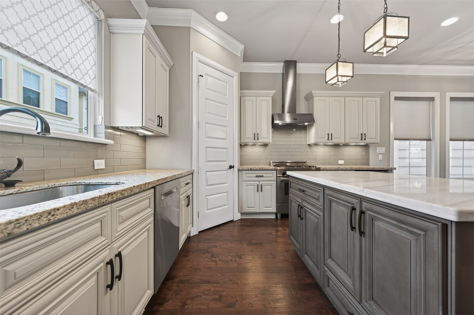 1429 W 21st Street, Houston, TX 77008 Plenty of cabinets, plus a large island with contrasting countertop and paint color. Pendant task lighting overhead.