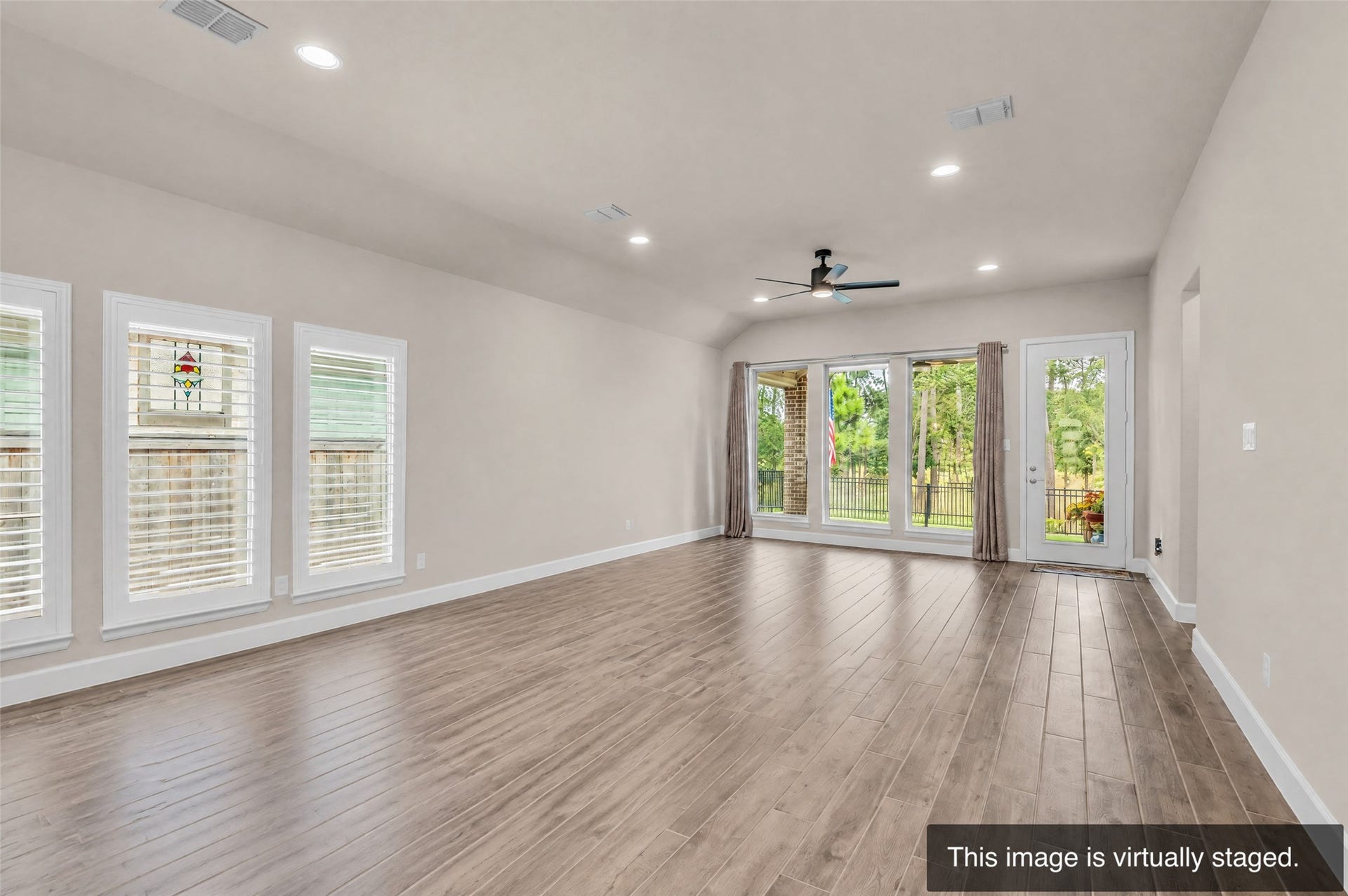 14858 Whistling Duck Lane, Magnolia, TX 77354 Living Room and Dining room furniture removed show the openness of the living space. Notice the plantation shutters. (Virtually enhanced)