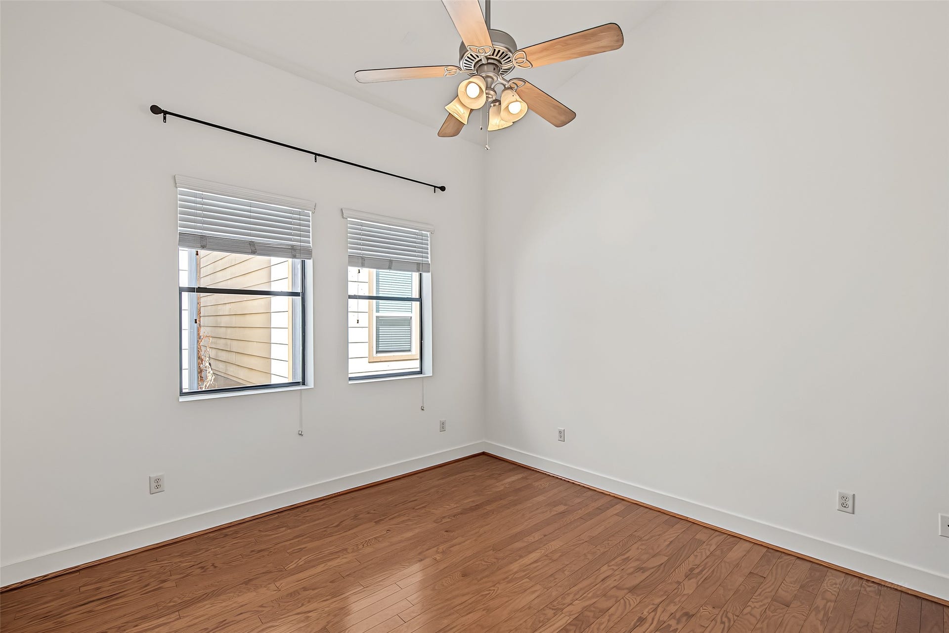 1555 Birdsall Street, #A, Houston, TX 77007 Upstairs, retreat to a serene primary bedroom suite highlighted by gleaming hardwood floors, soaring ceilings, and a classic ceiling fan.