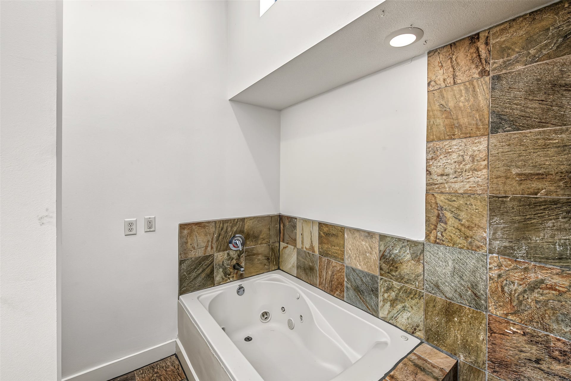 1555 Birdsall Street, #A, Houston, TX 77007 Designed for ultimate relaxation, the primary en-suite features both a deep whirlpool jetted tub and a separate walk-in shower framed in rich, natural slate tile from floor to ceiling.