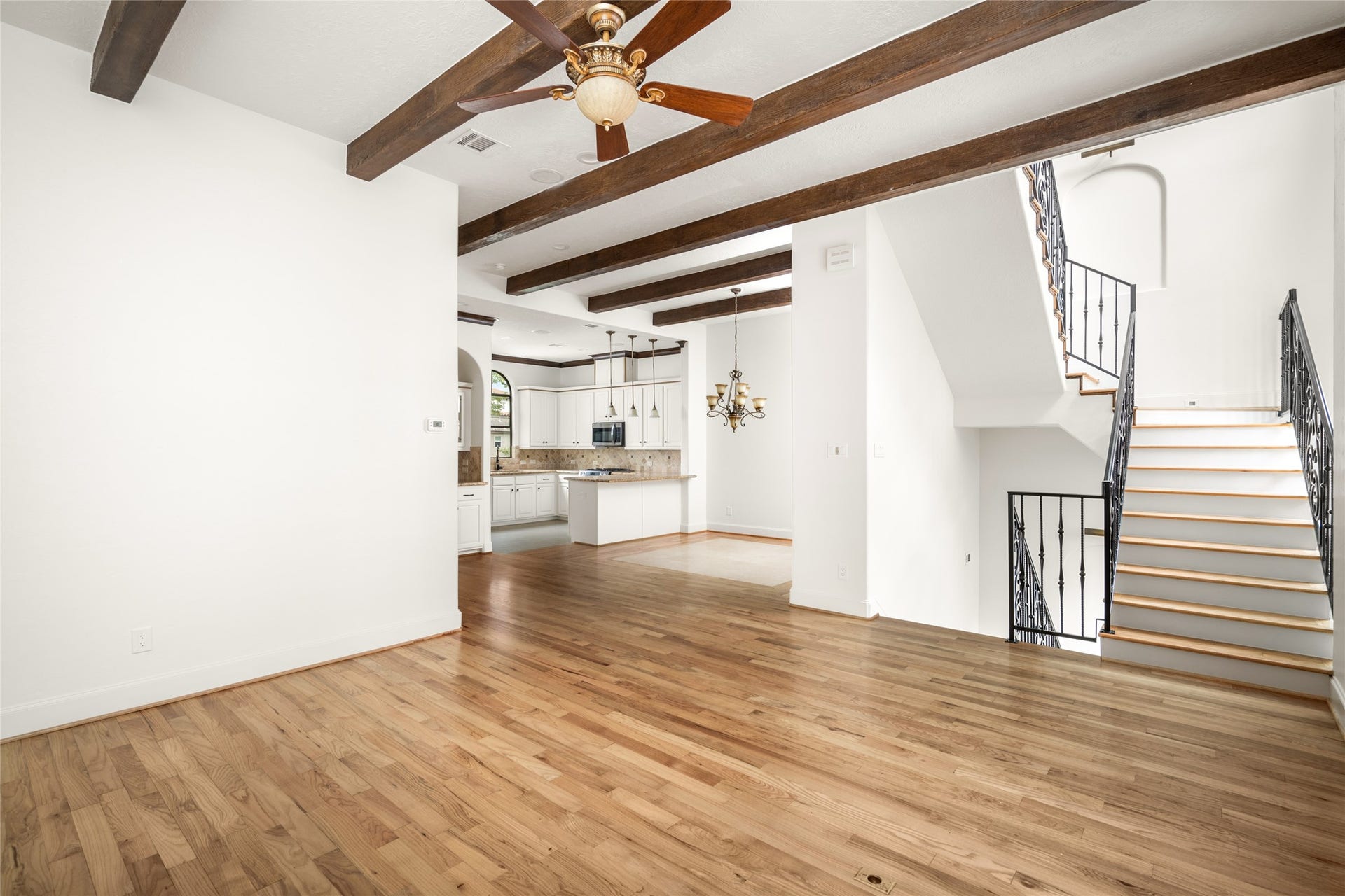 5218 Feagan Street, #D, Houston, TX 77007 Second level, view of the living room and dining room featuring wood beams and newly refinished hardwood floors.