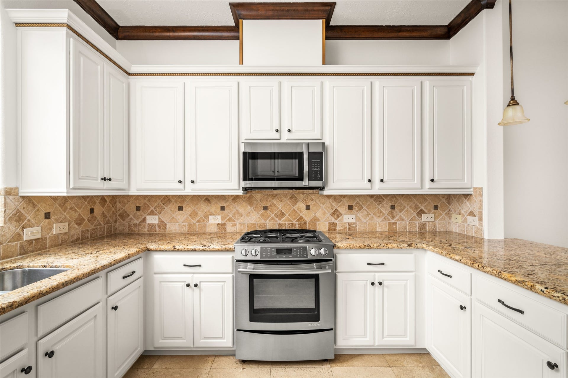 5218 Feagan Street, #D, Houston, TX 77007 Bright kitchen featuring white cabinetry, granite countertops, a decorative tile backsplash, stainless steel appliances, and elegant dark wood ceiling beams.