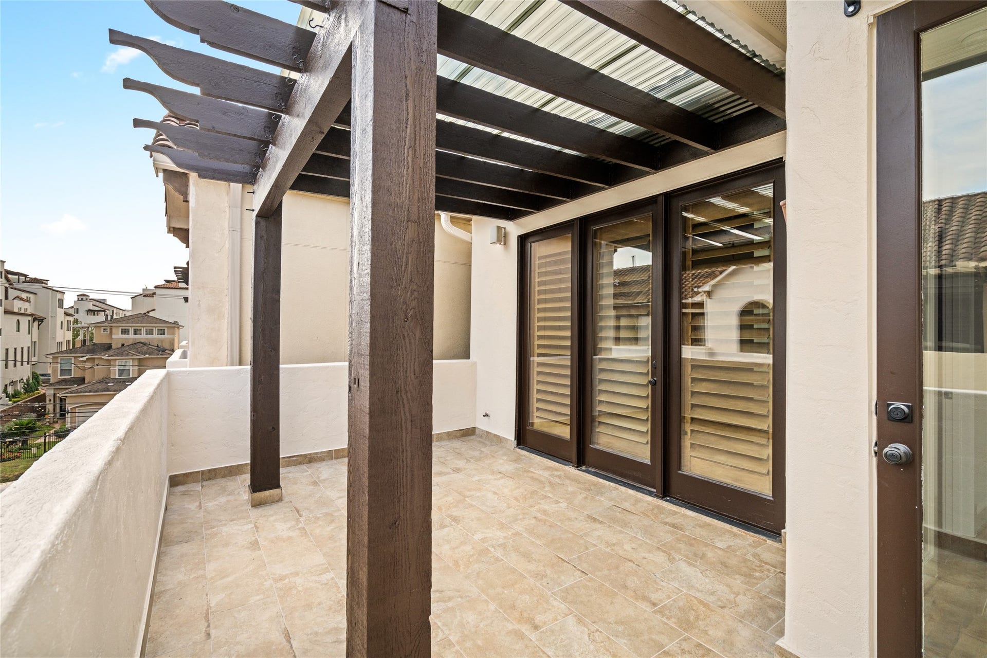 5218 Feagan Street, #D, Houston, TX 77007 Third floor - Private covered balcony featuring a pergola-style roof, tile flooring, and direct access to the primary suite.