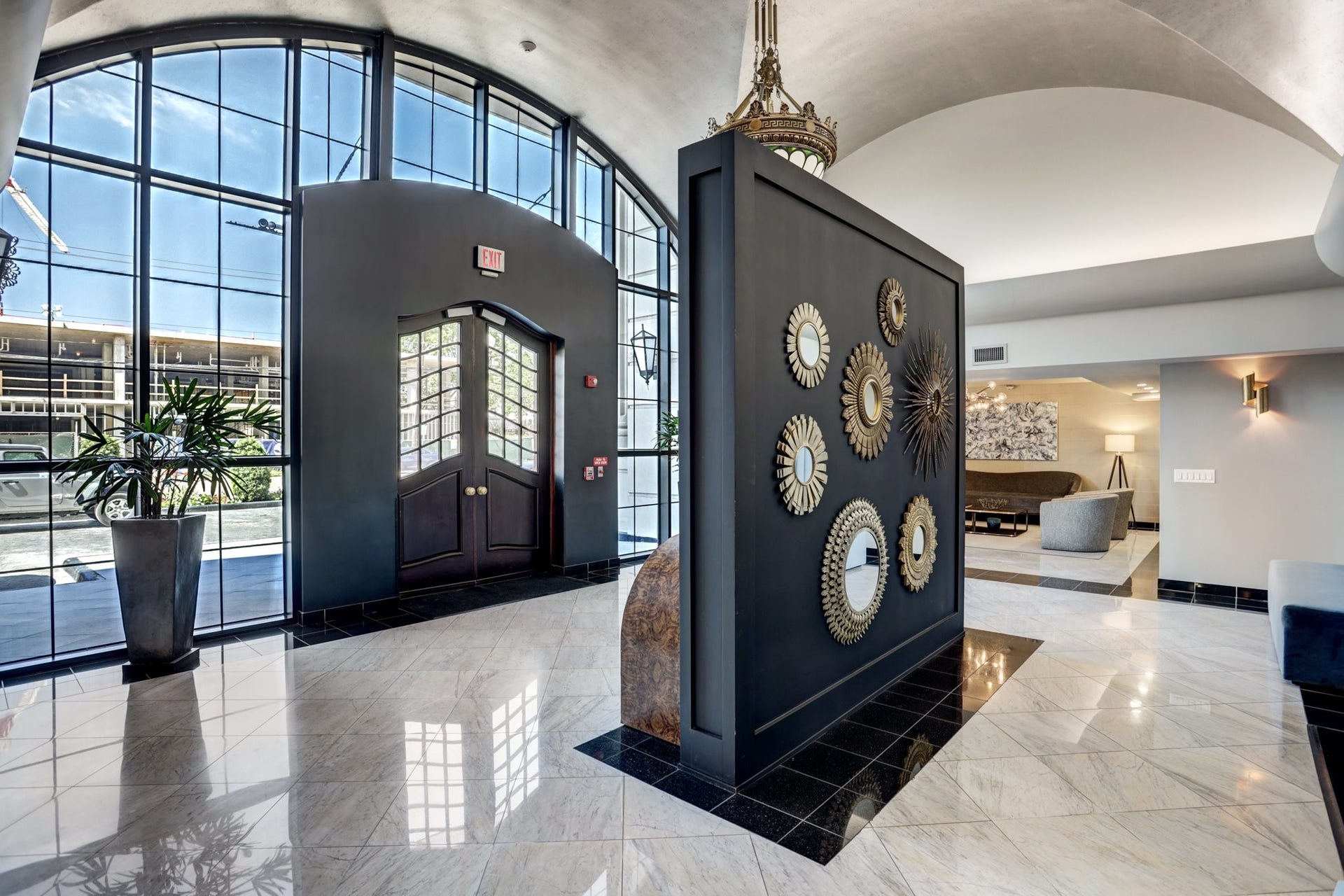 A dramatic arched window fills the interior with natural light, highlighting the polished floors and distinctive architectural details. Decorative accents and graceful ceiling treatments reinforce the building's European character.