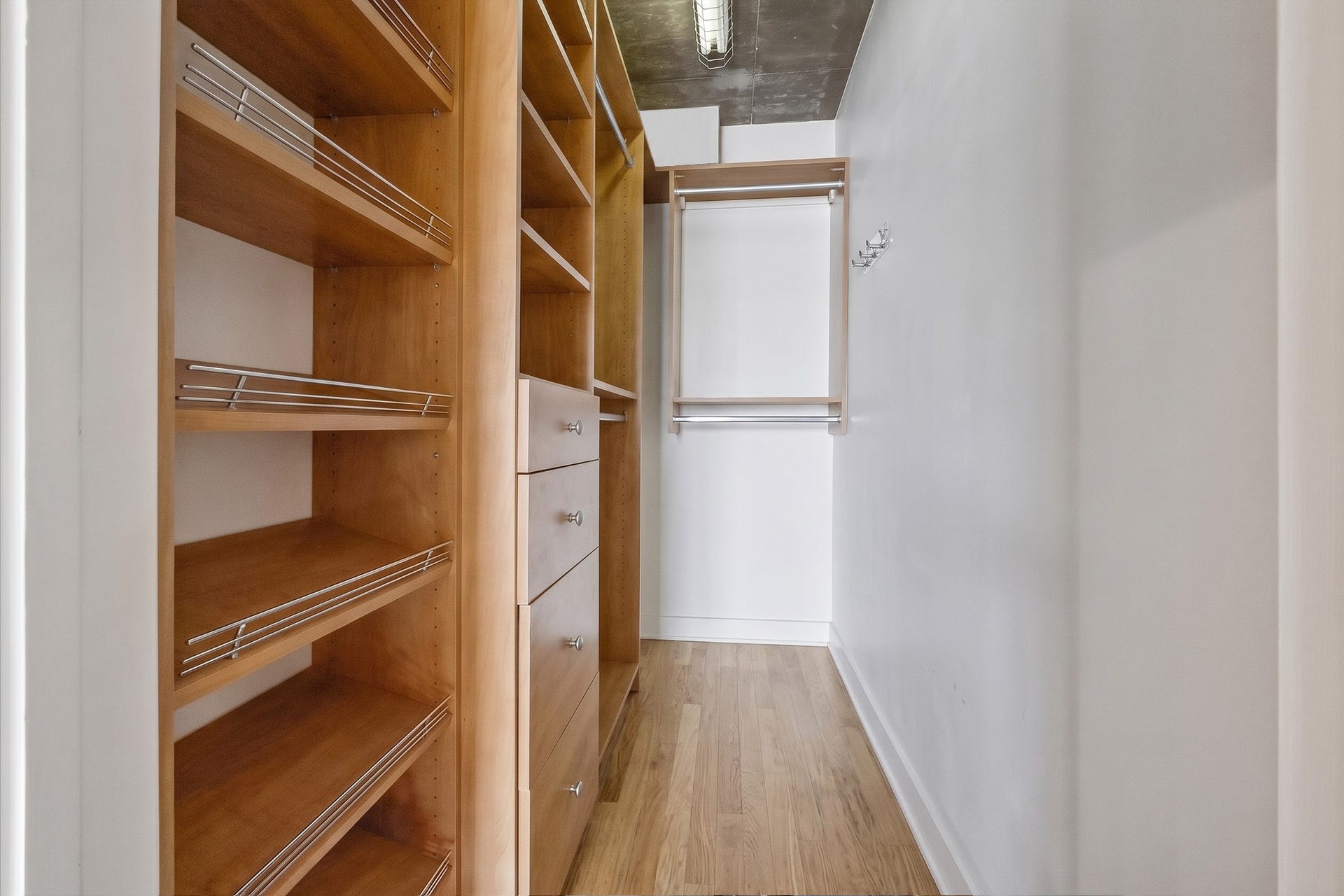 The walk-in closet features a custom California Closets organization system with open shelving, hanging space, and dedicated storage compartments. A thoughtful addition that maximizes storage within the residence.