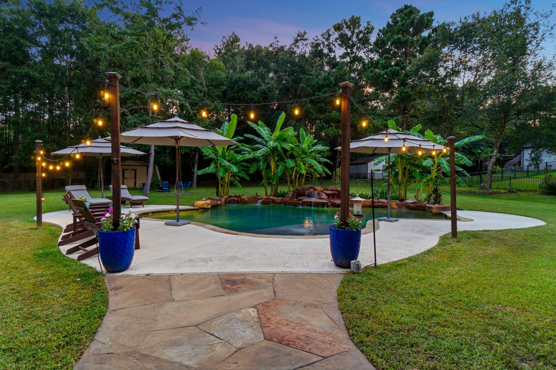 11612 Princess Ann Court, Montgomery, TX 77316 Resort-style backyard with a saltwater PebbleTec pool, waterfalls, and lush landscaping.