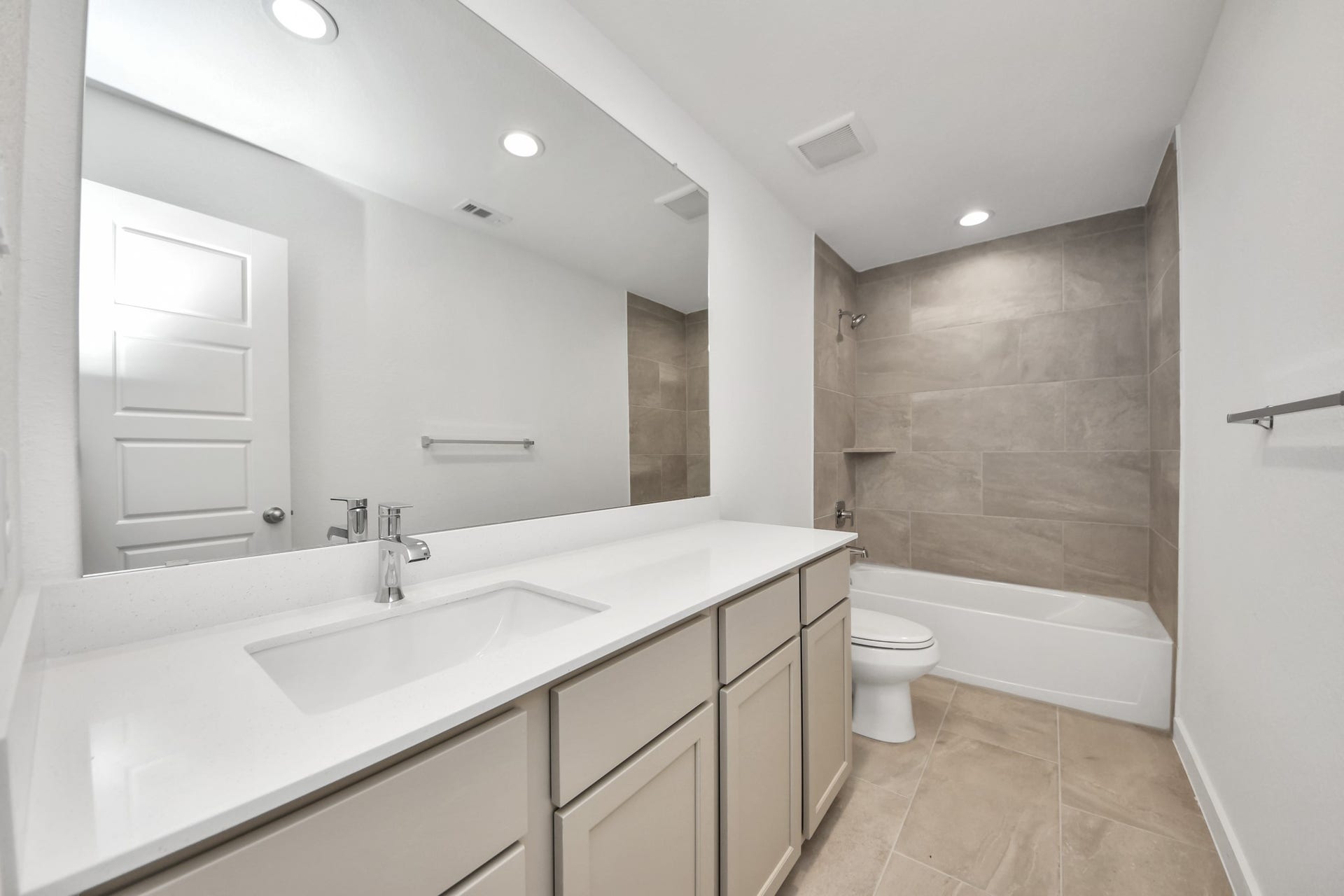 2114 Della Lakes Court, Fresno, TX 77545 Secondary bath features tile flooring, bath/shower combo with tile surround, light stained wood cabinets, beautiful light countertop. Sample photo of completed home with similar floor plan. Actual colors and selections may vary.