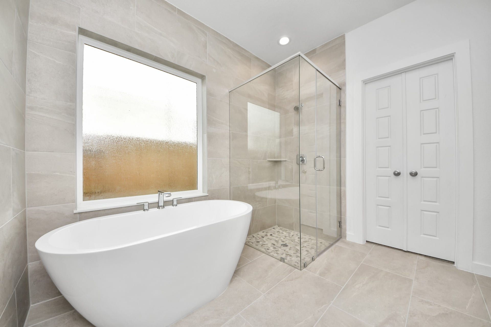 2114 Della Lakes Court, Fresno, TX 77545 Indulge in a spa-like retreat within the confines of this primary bathroom. Delight in a spacious walk-in shower enveloped in stylish tile surround, unwind in a separate garden tub adorned with custom detailing. Sample photo of completed home with similar floor plan. Actual colors and selections may vary.