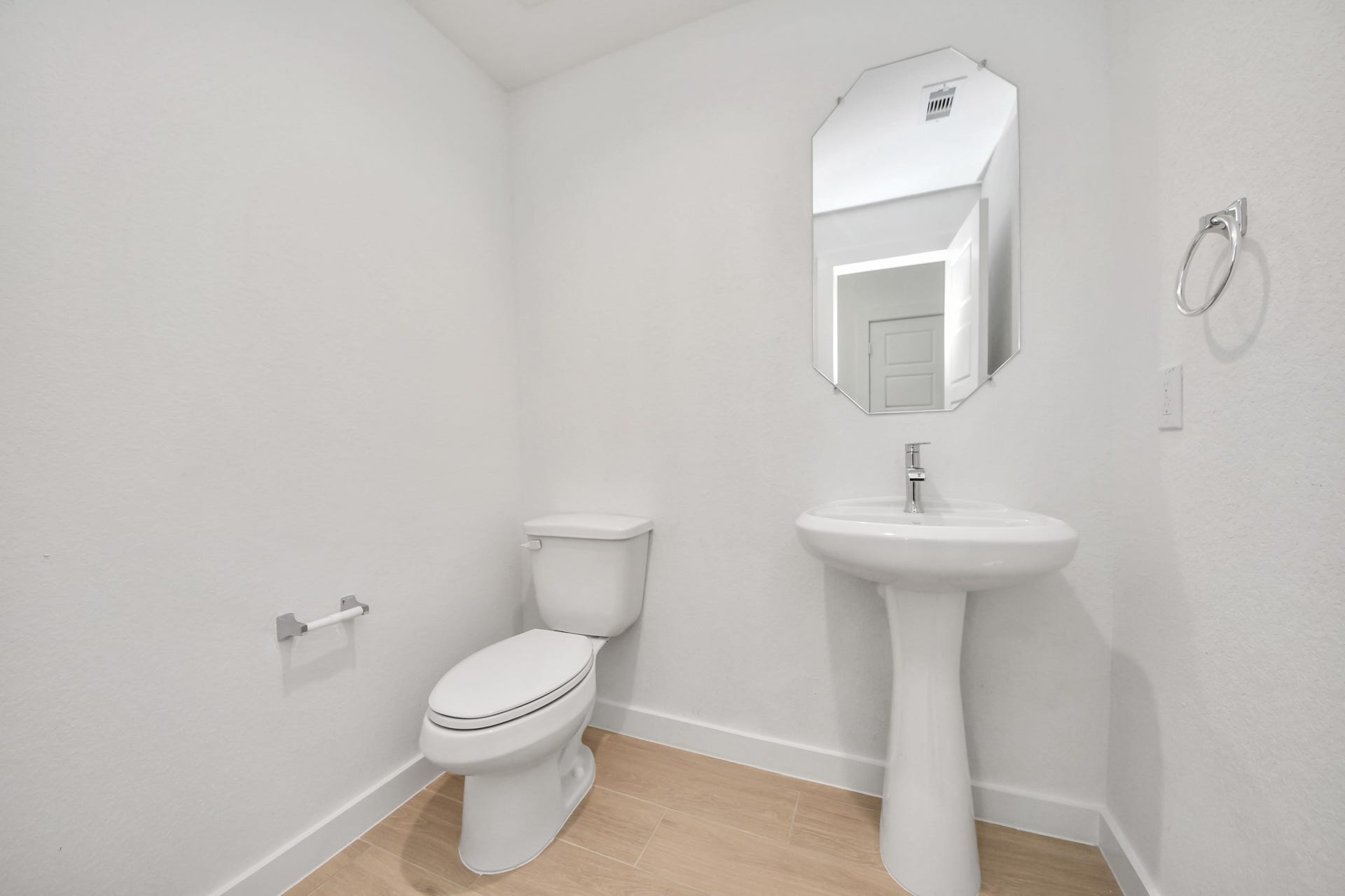 2114 Della Lakes Court, Fresno, TX 77545 This half bathroom features a stylish pedestal sink, modern hardware, and bright recessed lighting, creating a sleek and inviting space. Sample photo of completed home with similar floor plan. Actual colors and selections may vary.