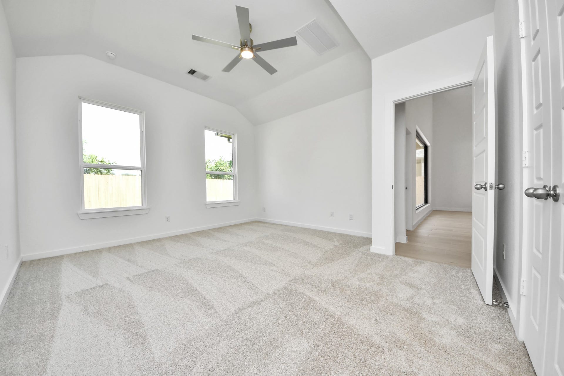 2114 Della Lakes Court, Fresno, TX 77545 Come and unwind after a long day in this magnificent primary suite! This spacious room features plush carpet, warm paint, high ceilings and large windows with privacy blinds. Sample photo of completed home with similar floor plan. Actual colors and selections may vary.