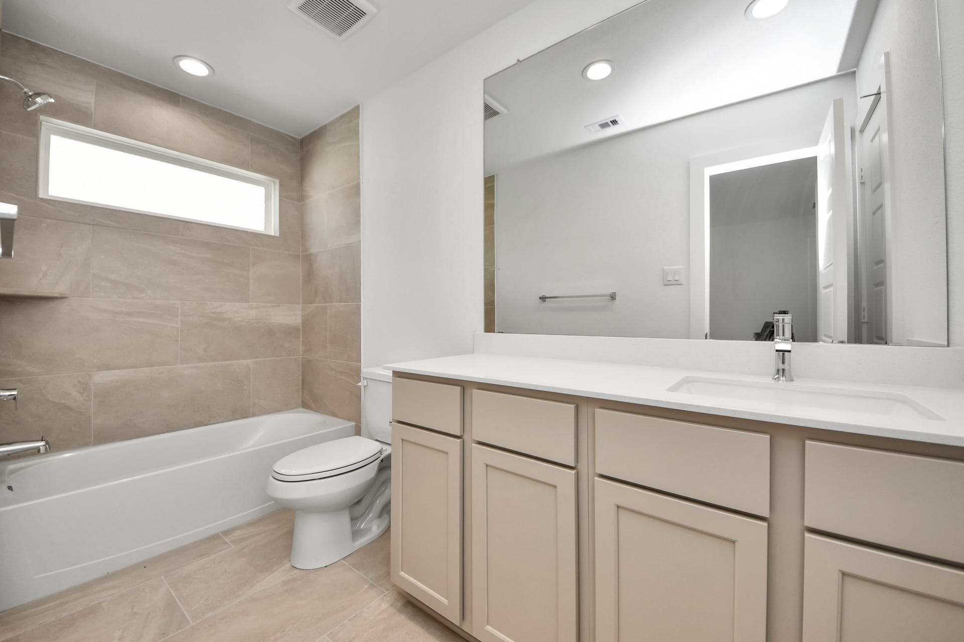 2114 Della Lakes Court, Fresno, TX 77545 Secondary bath features tile flooring, bath/shower combo with tile surround, light stained wood cabinets, beautiful light countertop. Sample photo of completed home with similar floor plan. Actual colors and selections may vary.