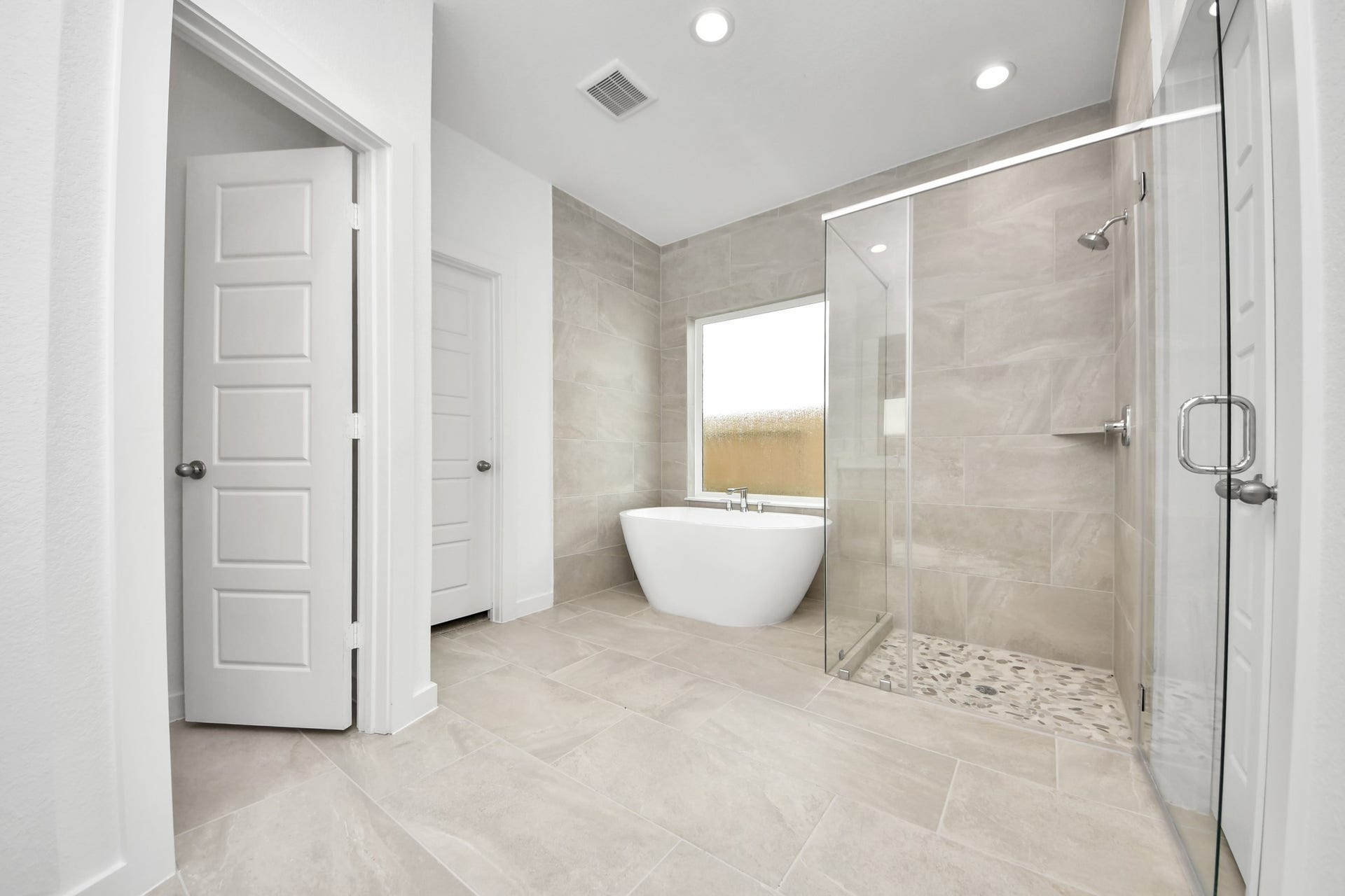 2114 Della Lakes Court, Fresno, TX 77545 Escape to a spa-like oasis in this primary bathroom. Enjoy a walk-in shower with tile surround, a separate garden tub with custom detailing, and an elegant vanity featuring light countertops, modern hardware, and beautiful recessed lights. Experience luxury and relaxation in every detail. Sample photo of completed home with similar floor plan. Actual colors and selections may vary.