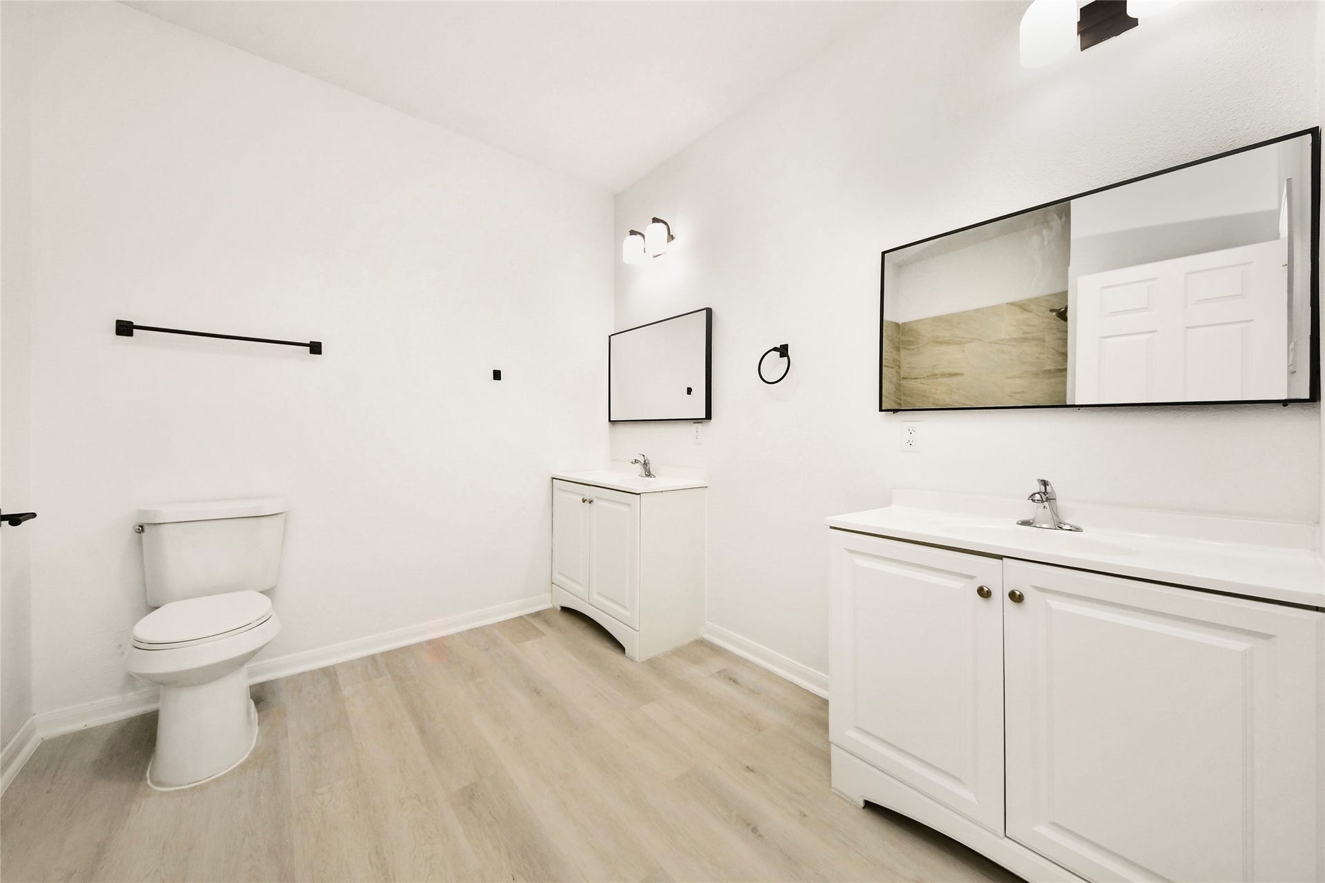 4615 Collingsworth Street, #AB, Houston, TX 77026 Spacious bathroom featuring elegant dual vanities with sleek mirrors, modern light fixtures, and a fresh, minimalist design.