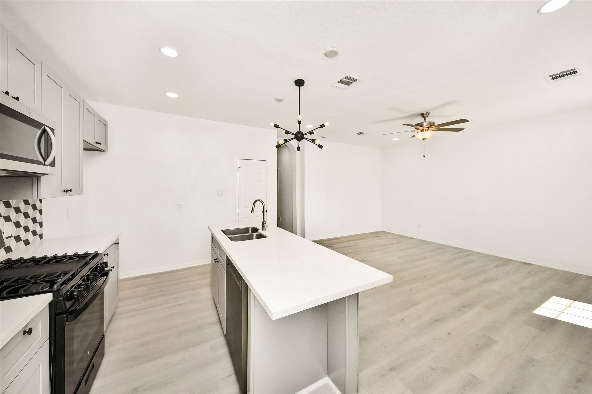 4615 Collingsworth Street, #AB, Houston, TX 77026 Bright and airy open-concept kitchen and living area featuring modern fixtures, sleek stainless steel appliances, and a spacious island perfect for entertaining.