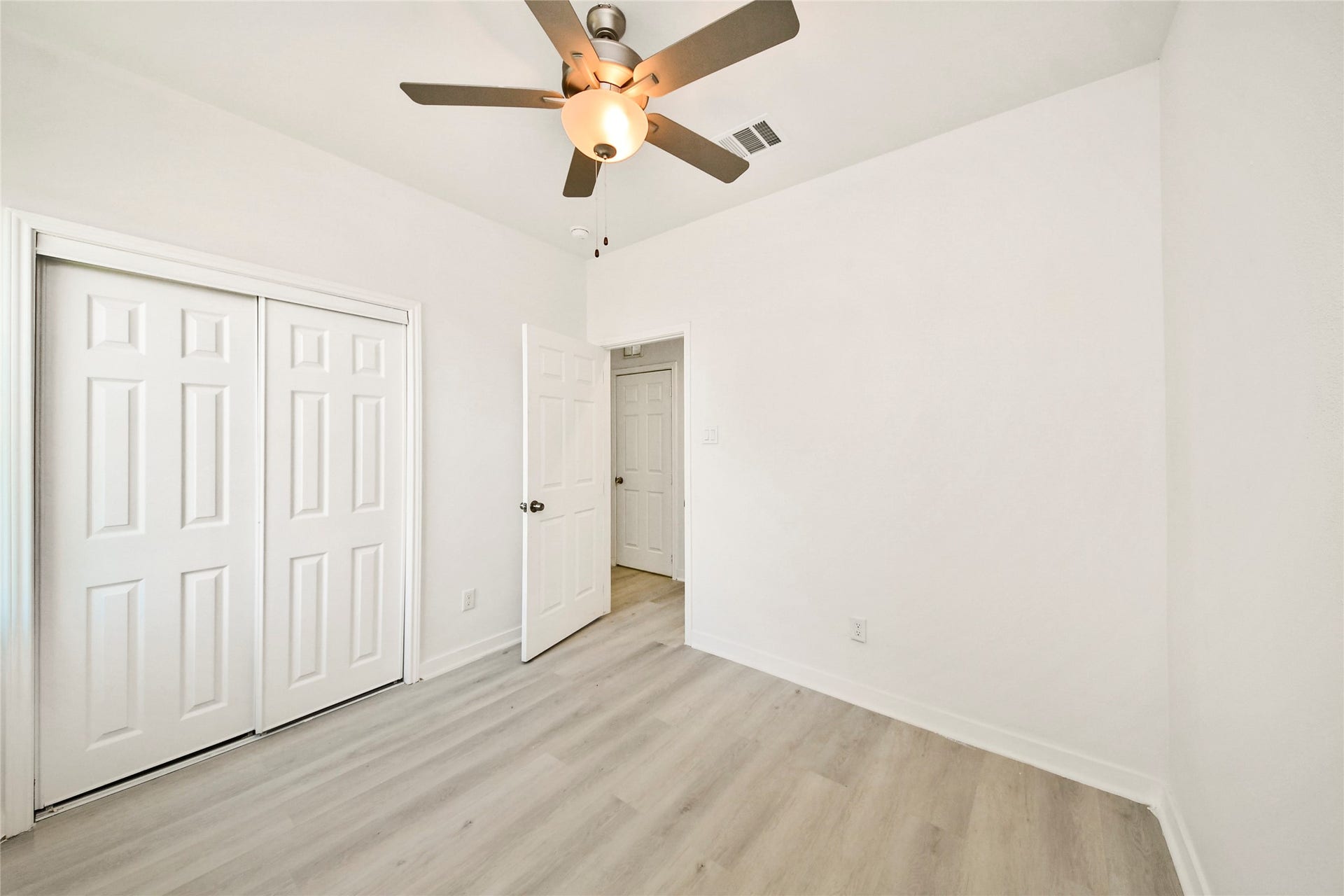 4615 Collingsworth Street, #AB, Houston, TX 77026 Bright room with modern light wood flooring, a ceiling fan, and ample closet space.