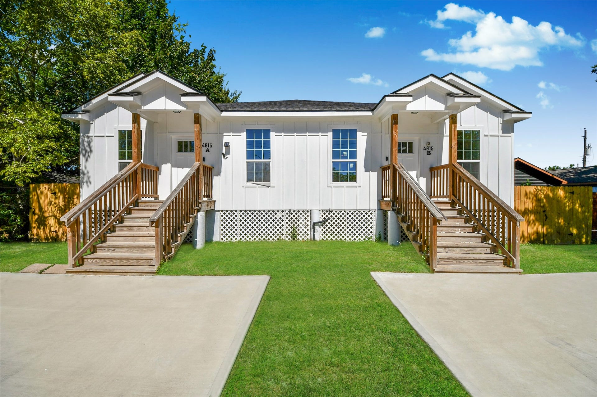 4615 Collingsworth Street, #AB, Houston, TX 77026 Charming duplex with modern white exterior, featuring two inviting front porches and a lush green lawn, perfect for comfortable living.