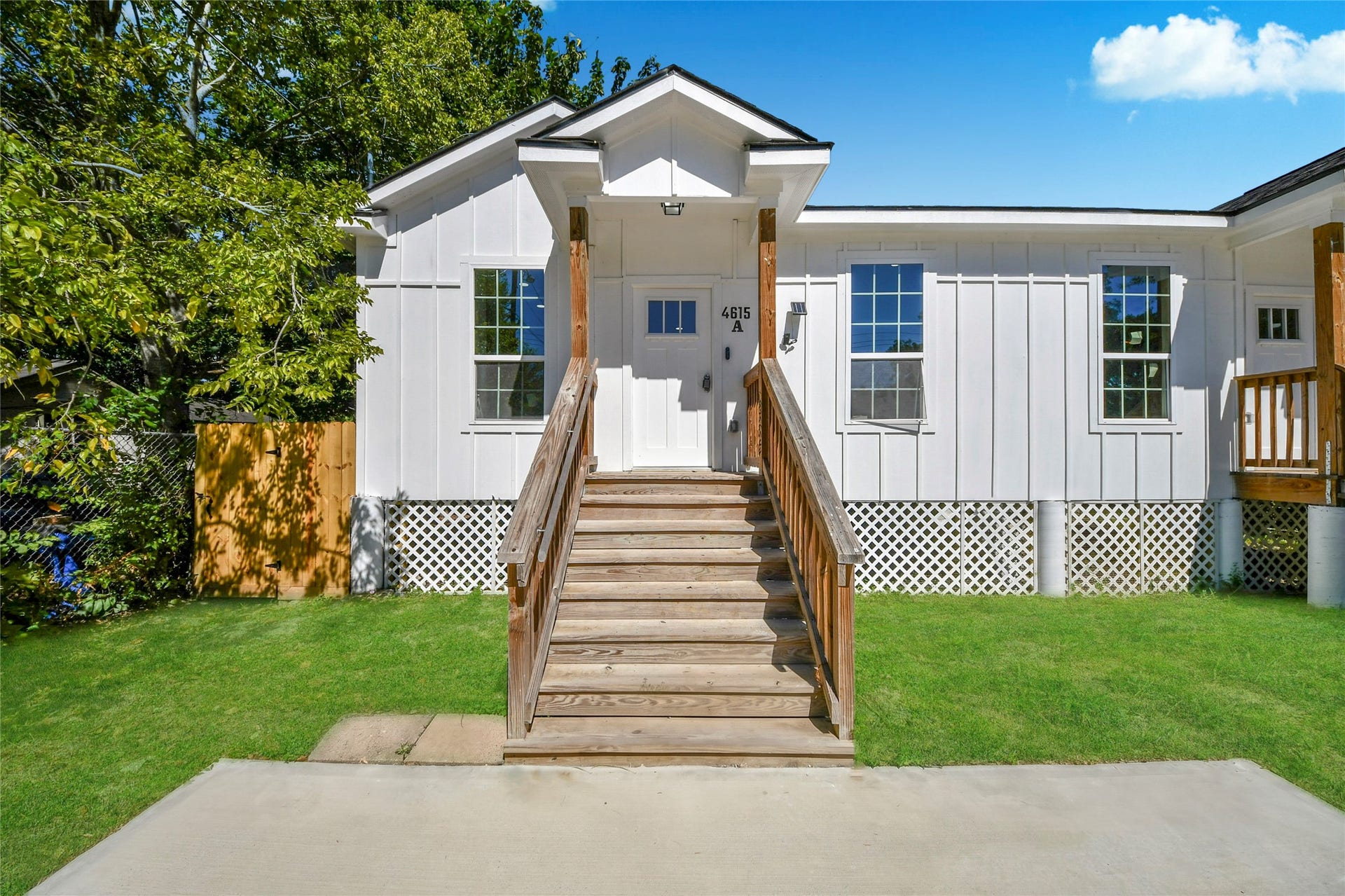4615 Collingsworth Street, #AB, Houston, TX 77026 Charming white home with a welcoming front porch, complemented by a lush green lawn and mature trees for added privacy.