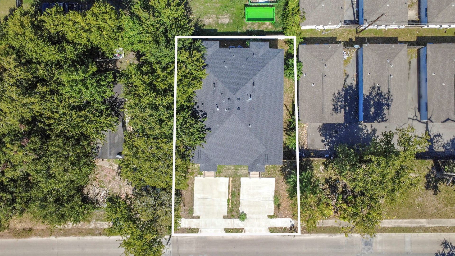4615 Collingsworth Street, #AB, Houston, TX 77026 Spacious property with a large roof and dual driveway, nestled among mature trees for added privacy.