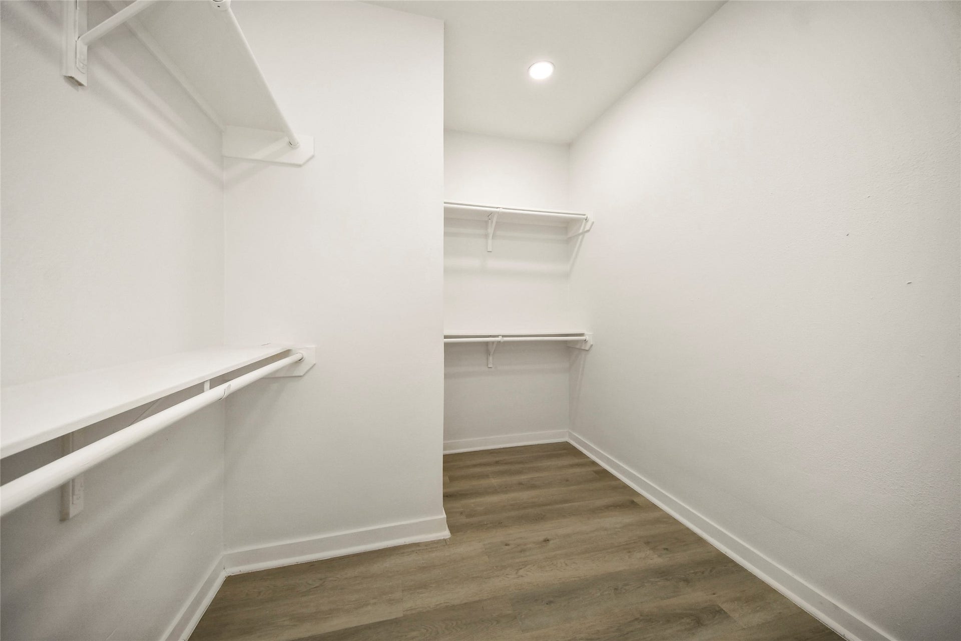 4615 Collingsworth Street, #AB, Houston, TX 77026 Spacious walk-in closet featuring ample shelving and hanging space, complemented by modern recessed lighting and elegant hardwood flooring.