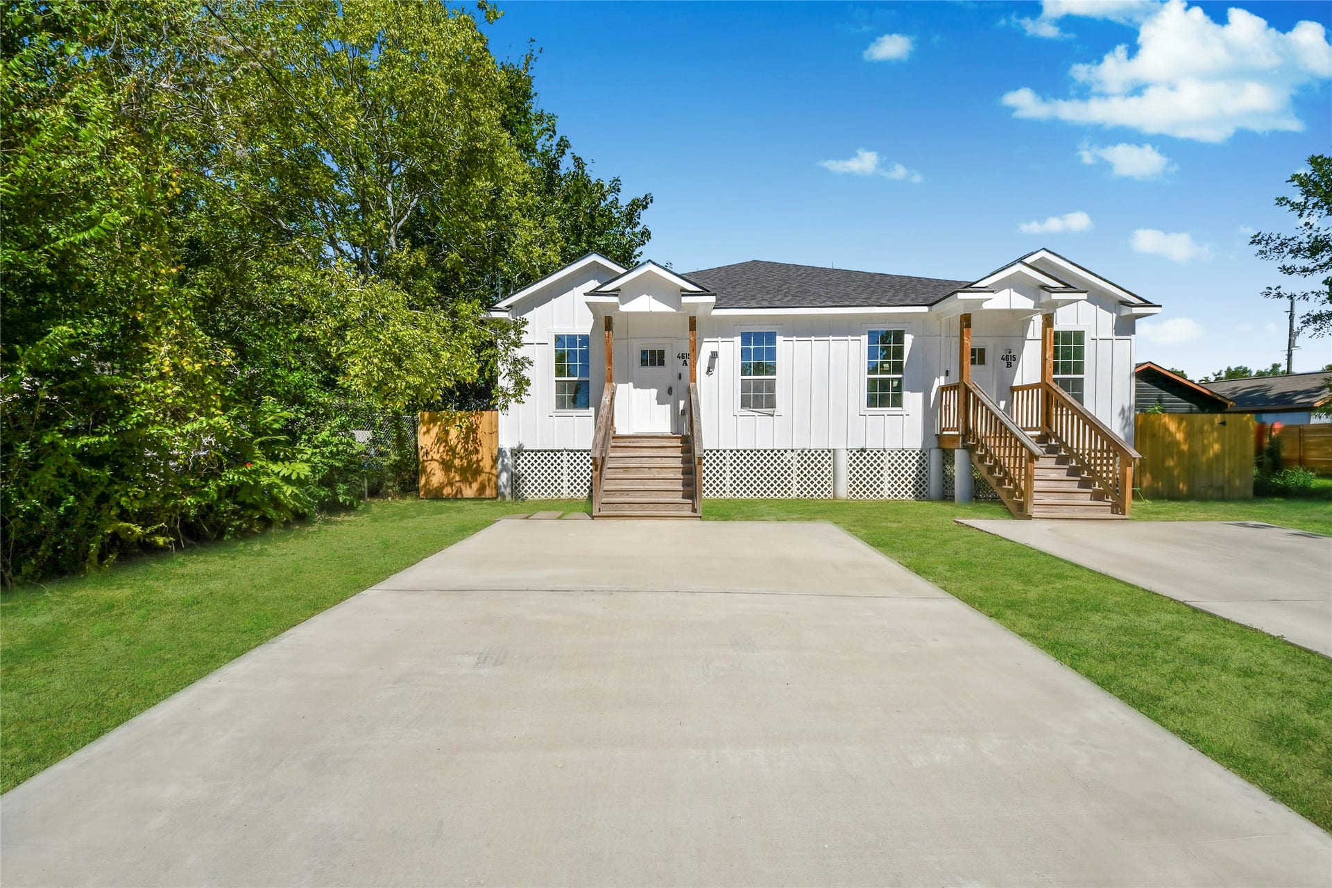 4615 Collingsworth Street, #AB, Houston, TX 77026 Charming white clapboard home with dual entry staircases, nestled in a lush, green setting, featuring a spacious driveway and inviting curb appeal.