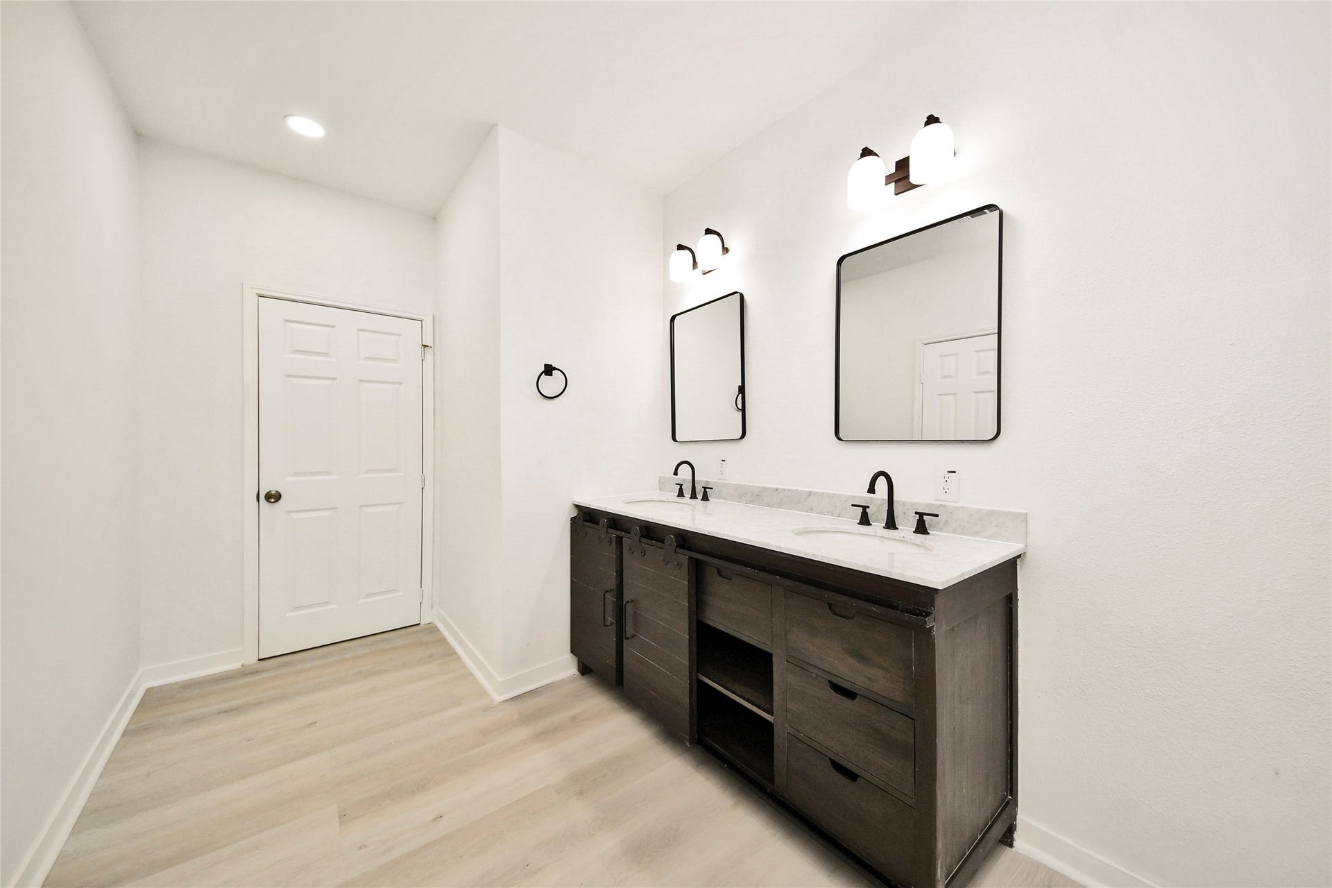 4615 Collingsworth Street, #AB, Houston, TX 77026 Sleek bathroom featuring a double vanity with modern fixtures, elegant dual mirrors, and stylish lighting, all set against a crisp, white backdrop.