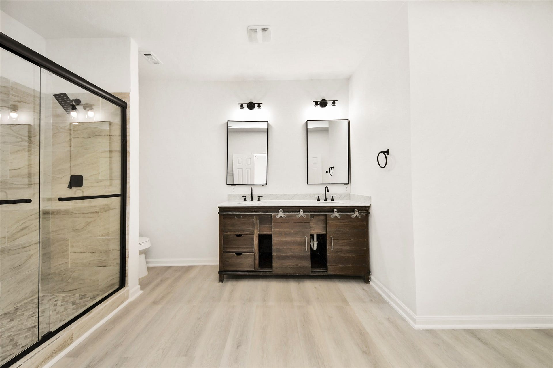 4615 Collingsworth Street, #AB, Houston, TX 77026 Elegant bathroom featuring a spacious glass-enclosed shower and dual-sink vanity with sleek modern fixtures.