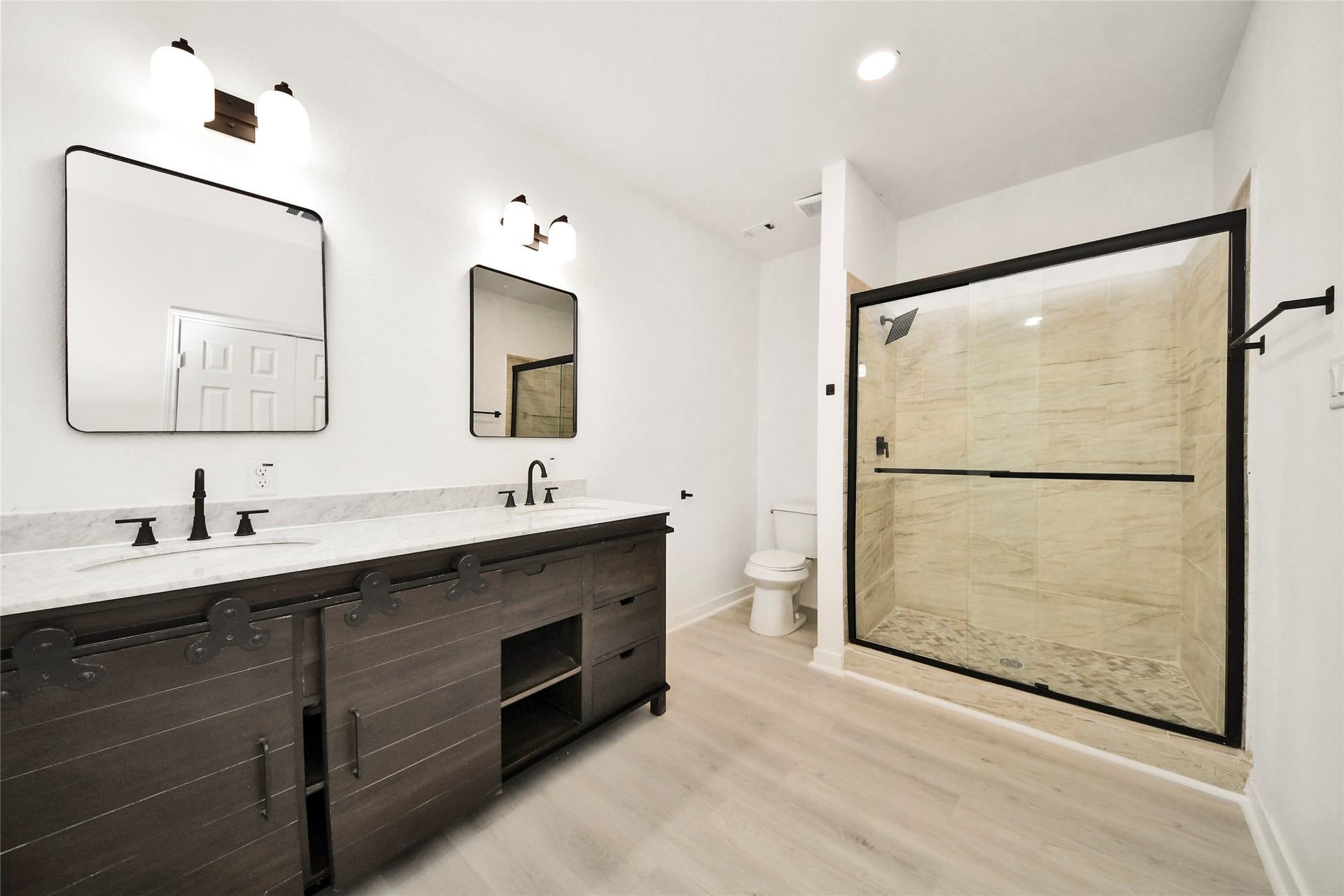 4615 Collingsworth Street, #AB, Houston, TX 77026 Spacious bathroom featuring a sleek double vanity with modern fixtures and a large walk-in shower with elegant tilework.