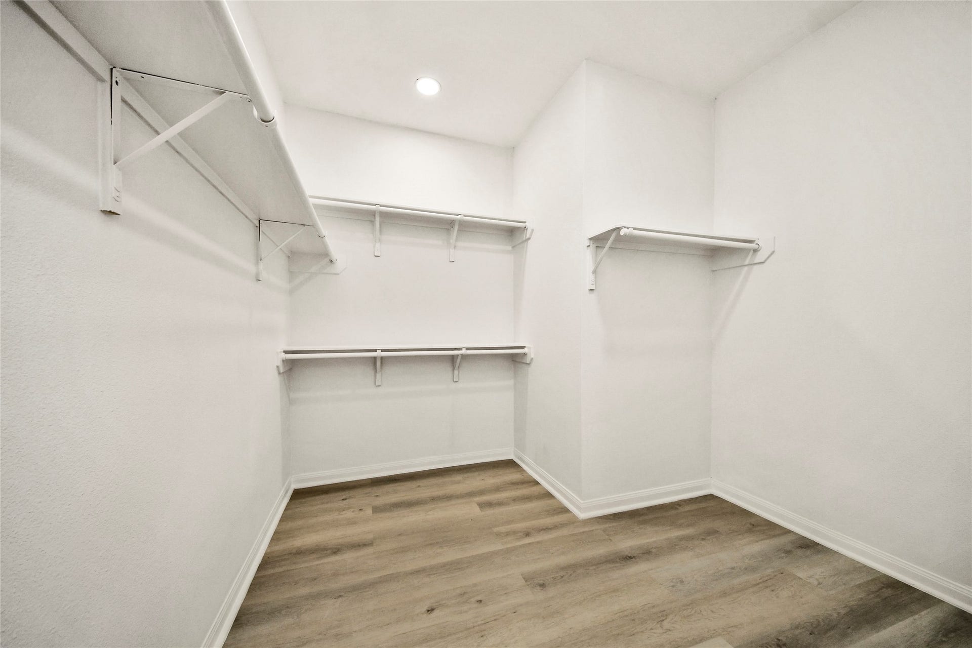 4615 Collingsworth Street, #AB, Houston, TX 77026 Spacious walk-in closet with ample shelving and hanging space, featuring sleek wood flooring and bright lighting.
