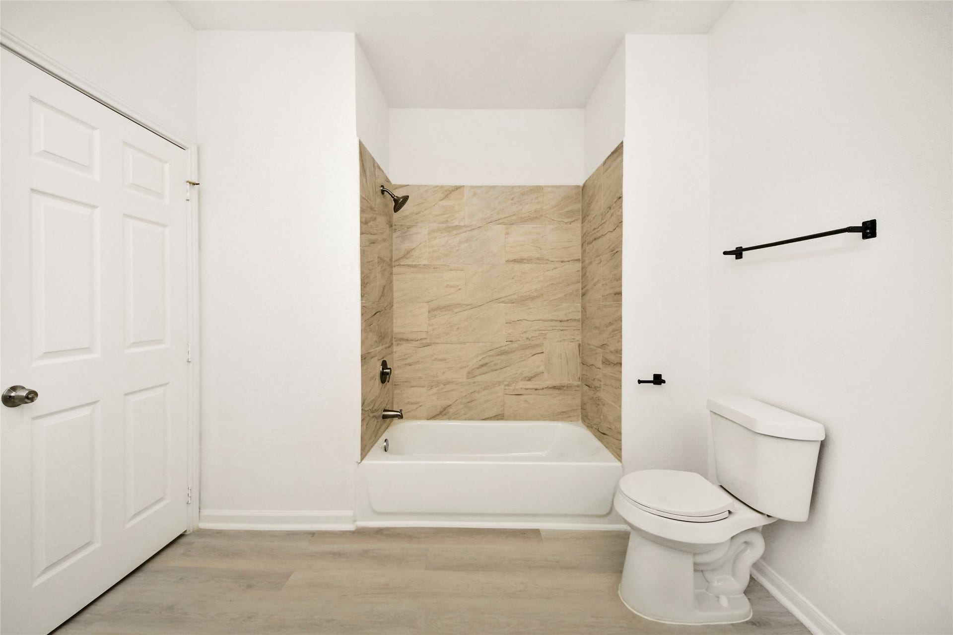 4615 Collingsworth Street, #AB, Houston, TX 77026 Bright and modern bathroom featuring a sleek bathtub with elegant tile surround, complemented by fresh white walls and contemporary fixtures.