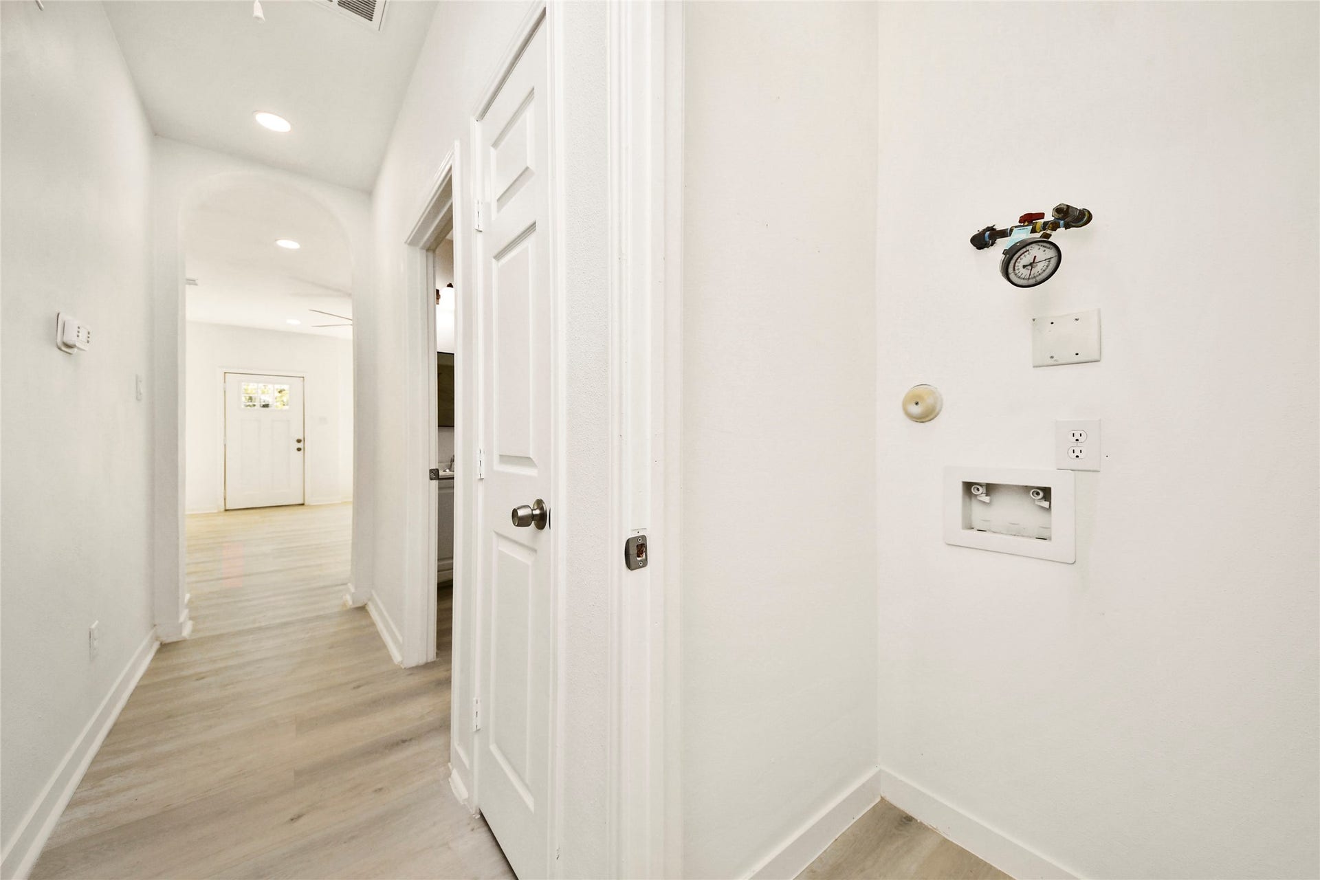 4615 Collingsworth Street, #AB, Houston, TX 77026 Bright hallway with modern recessed lighting and light wood flooring, leading to a cozy living area.