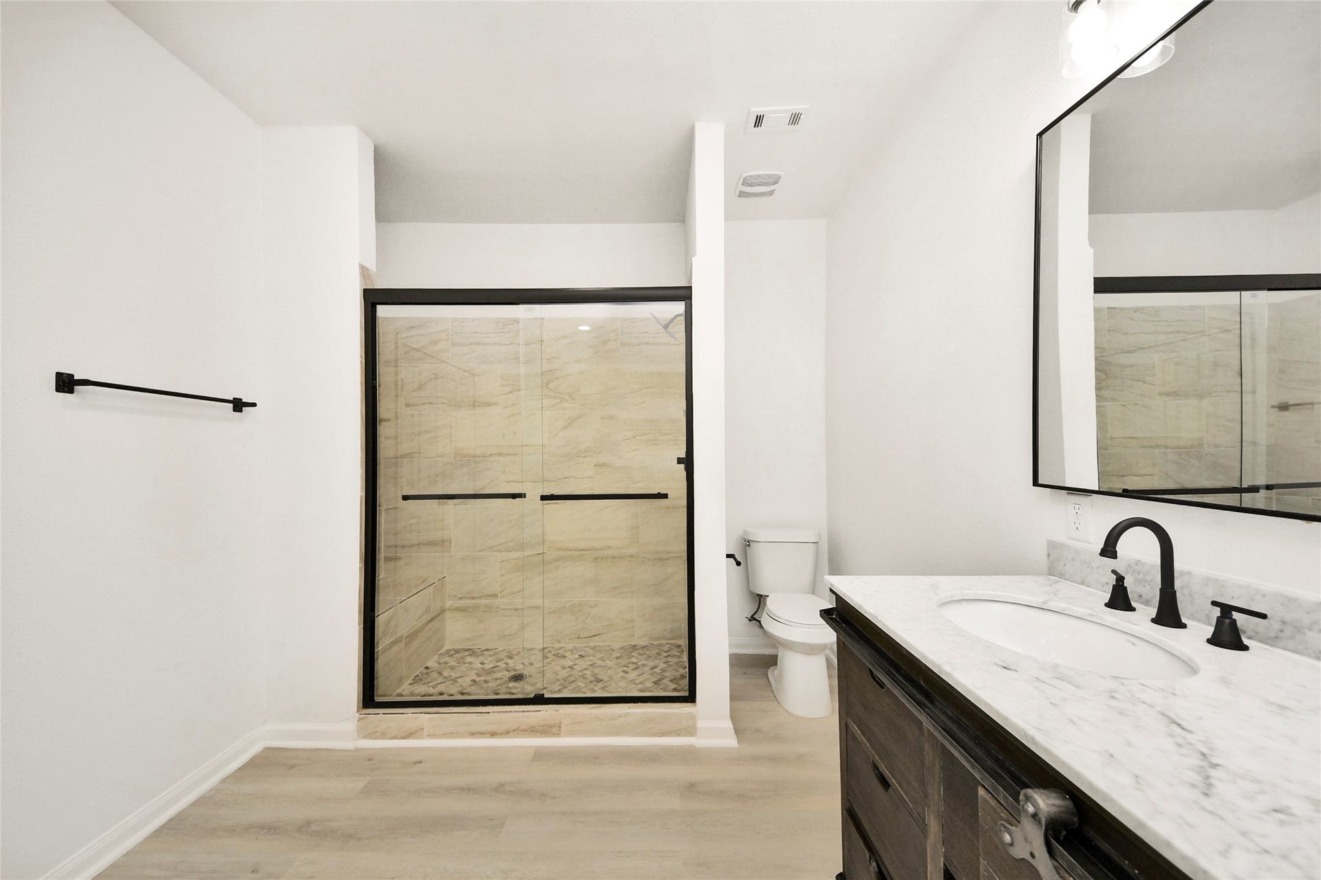 4615 Collingsworth Street, #AB, Houston, TX 77026 Elegant bathroom with a spacious glass-enclosed shower, sleek marble countertop, and modern fixtures.