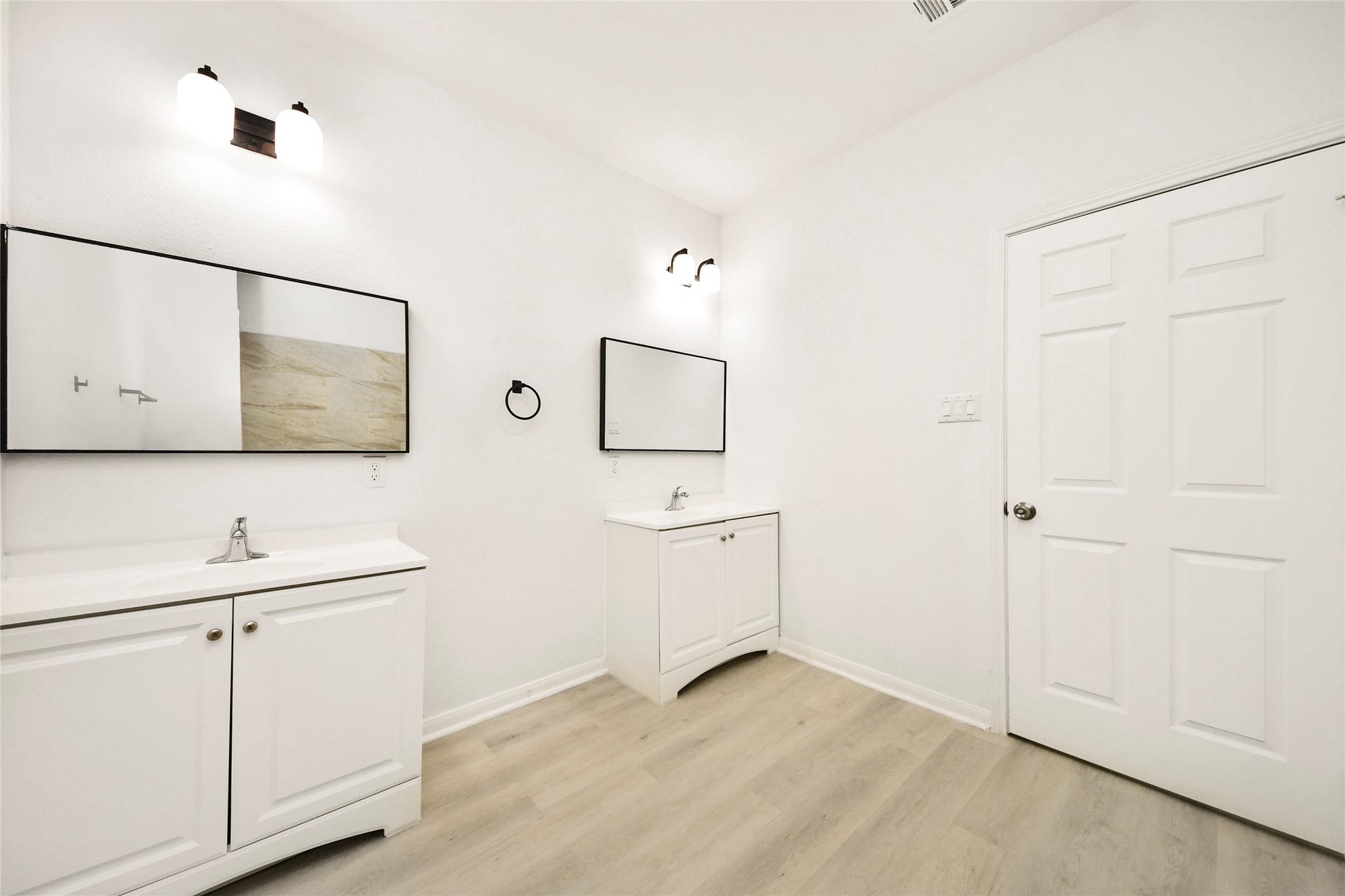 4615 Collingsworth Street, #AB, Houston, TX 77026 Bright and spacious bathroom featuring dual vanities, sleek mirrors, and modern fixtures, all set against a clean, minimalist design.