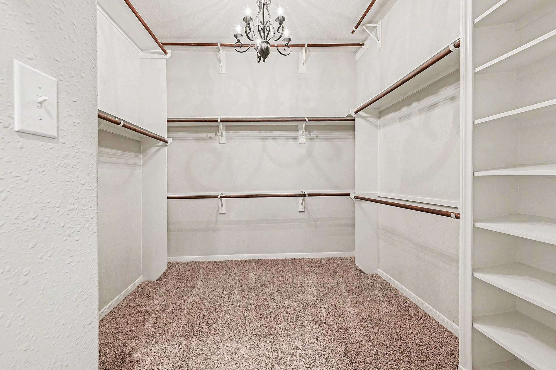 Look at 1 of 2 closets In Primary Bathroom (10.5 x 10.5) lots of shelfing, hanging space for all clothes and shoes with a chandlier for lighting.