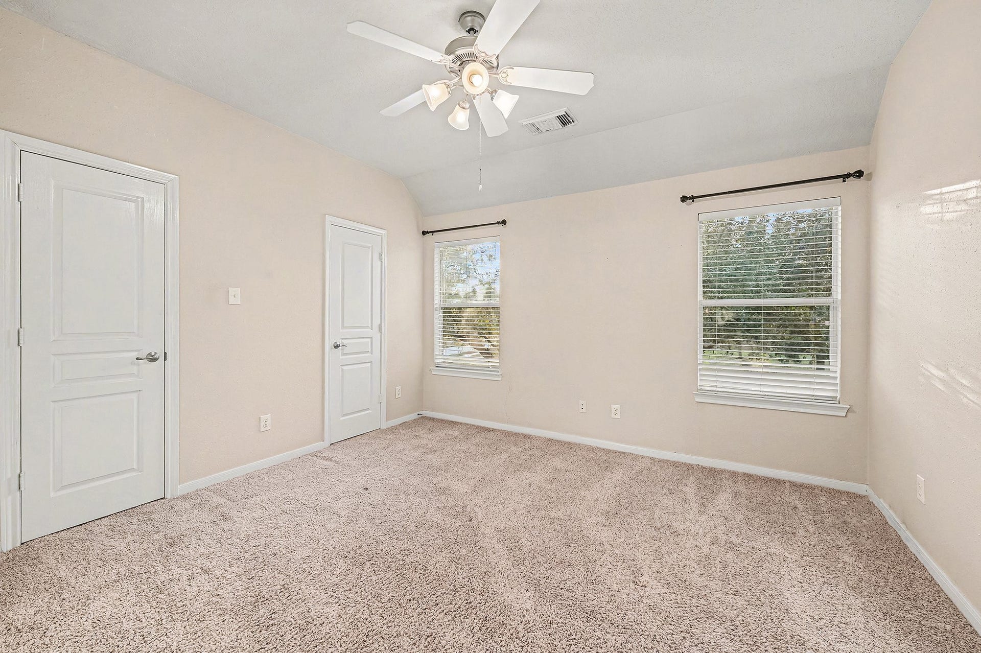 This view shows a very nuetral secondary bedroom without furniture. All secondary bedrooms are roomy with ceiling fan. All windows have faux blinds.