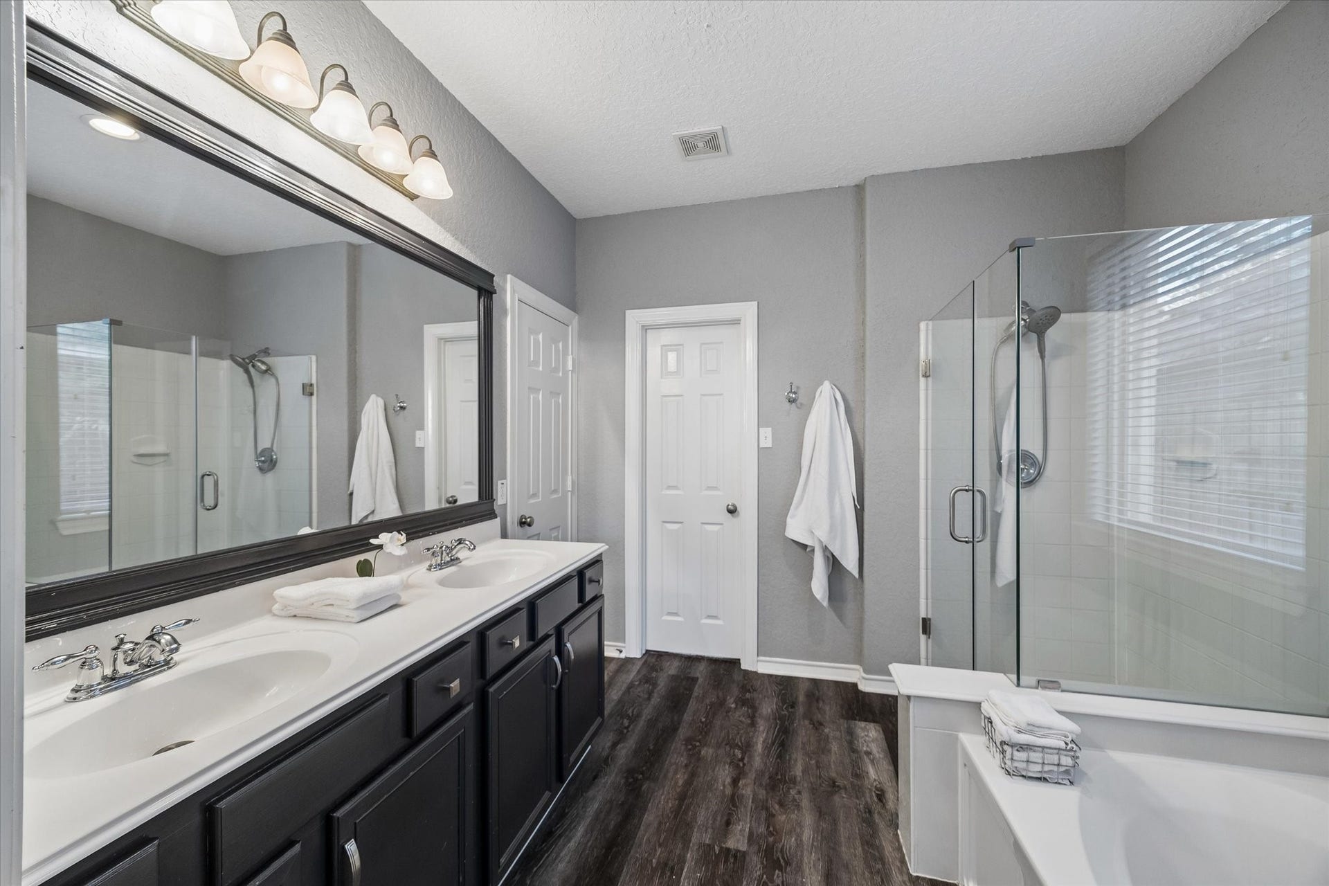 5115 Redleaf Forest Lane, Katy, TX 77494 The spacious primary bathroom features dual vanities with generous counter space, a large soaking tub, and a separate glass-enclosed shower. An oversized walk-in closet provides plenty of storage and completes this well-appointed primary suite.