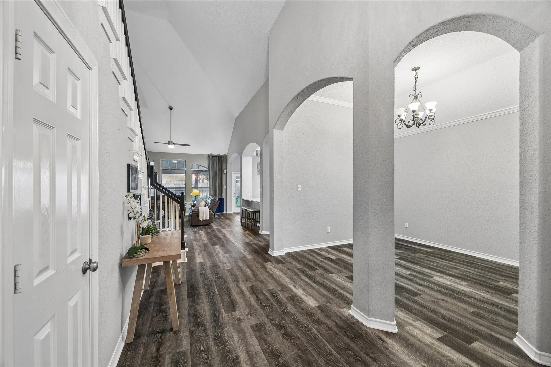 5115 Redleaf Forest Lane, Katy, TX 77494 Step inside to a grand, light-filled entryway featuring soaring ceilings, beautiful architectural archways, and gorgeous luxury vinyl plank flooring that extends throughout the entire first floor. The open, airy design creates an impressive first impression, with elegant views into the formal dining room and inviting living spaces beyond.