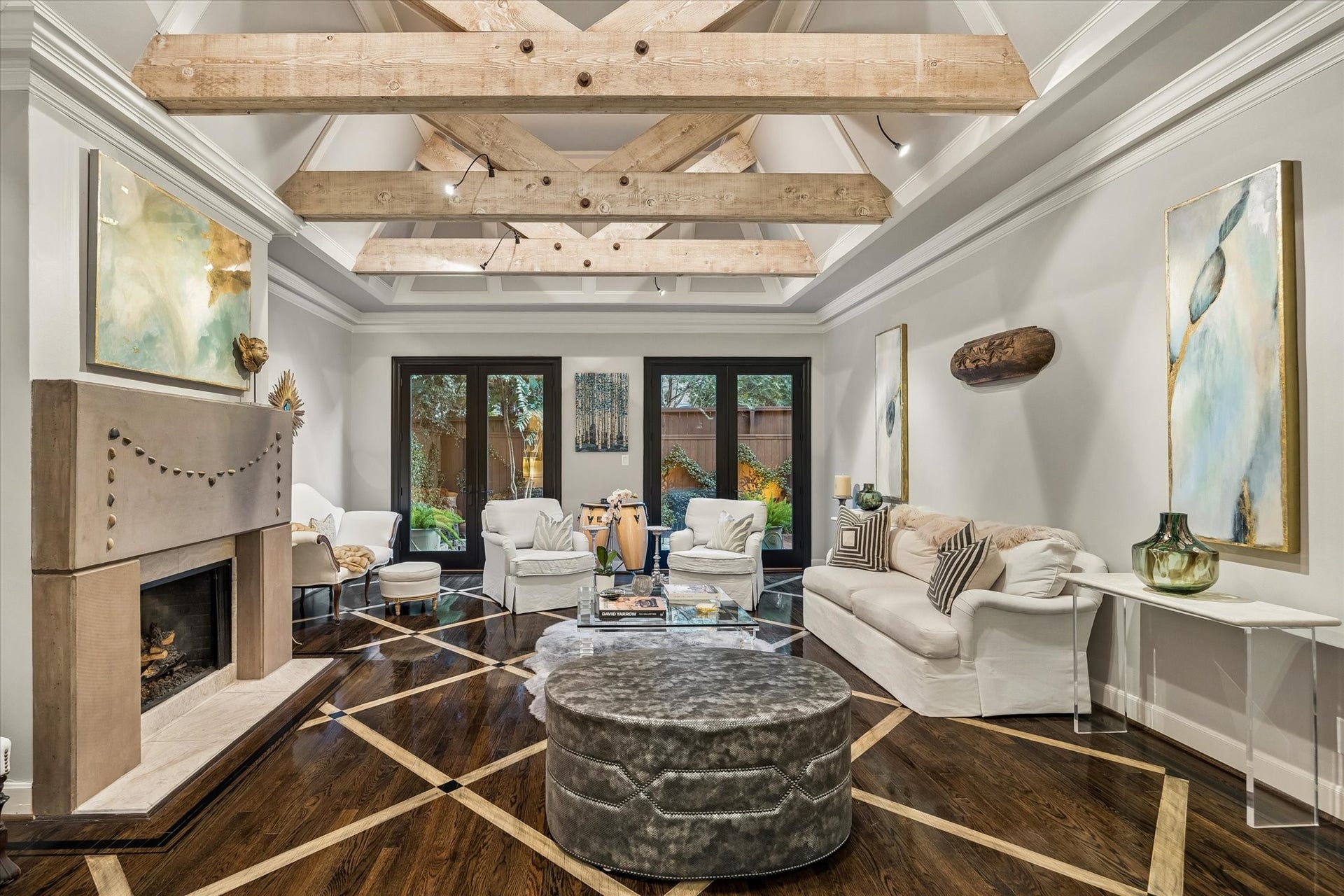 Around the corner from the Entry: Under foot in the commodious Great Room are glossy ebonized patterned hardwood floors; above you reclaimed beams punctuate soaring ceilings.