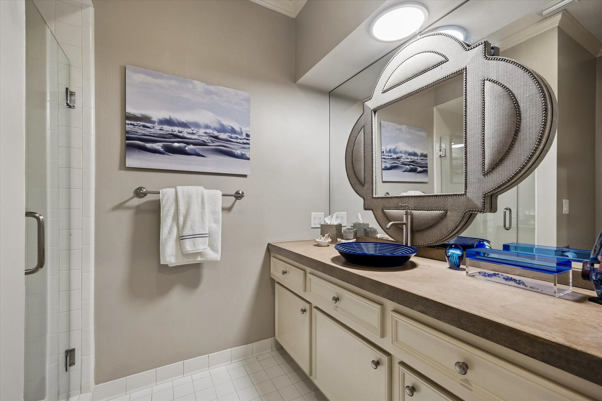 The private en suite Bath features an updated vanity with custom touches and a stall shower with a seamless glass door.