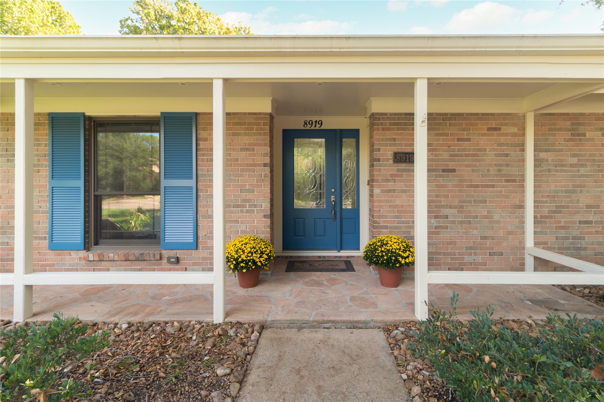 8919 Manhattan Drive, Houston, TX 77096 A welcoming covered front porch leads to the blue entry door with decorative glass