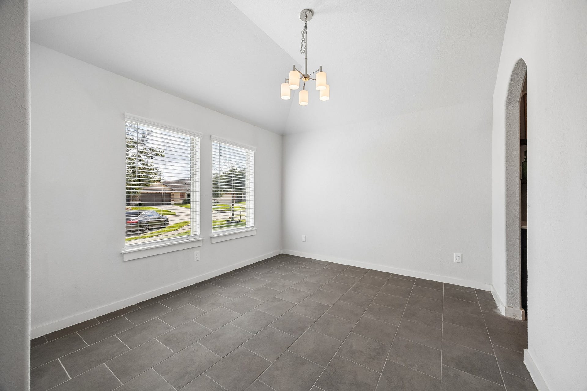 Natural lighting and neutral tile for ease of lifestyle and home maintenance fill this flex space that can be used for dining/ home office/ playroom or a second living space.
