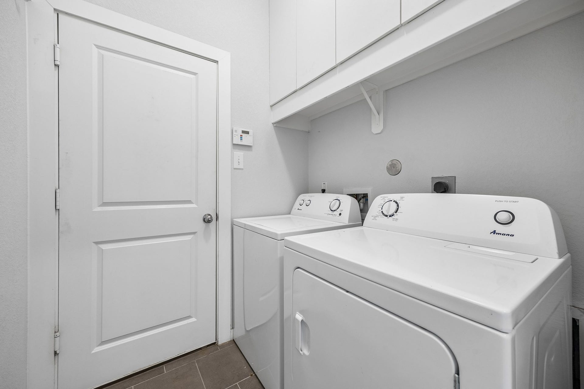 Spacious utility rom with cabinets to the ceiling for extra storage and organization.