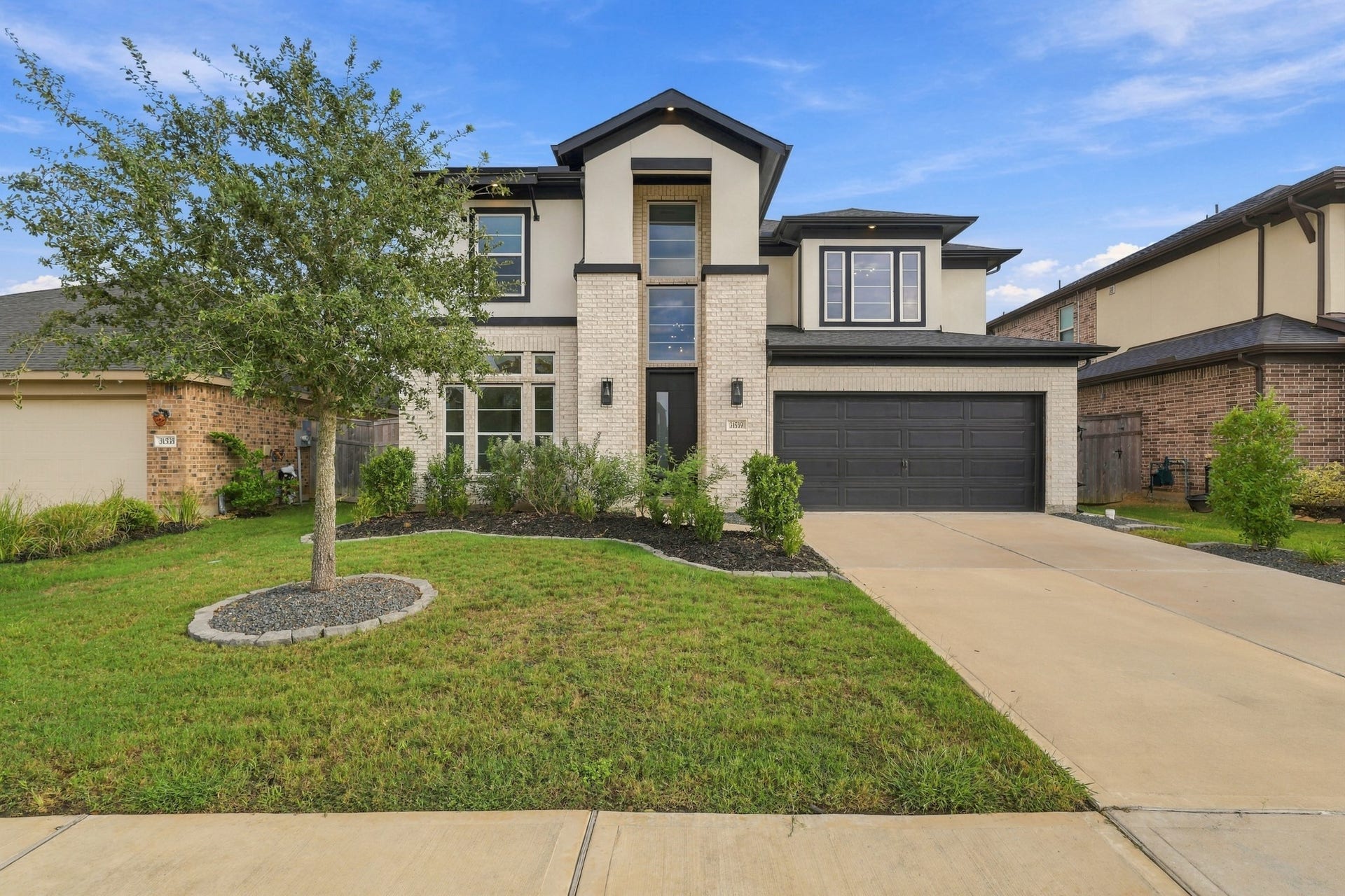 31539 Beacon Cove Trail, Fulshear, TX 77441 Stunning brick and stucco elevation with sophisticated architecture and pristine landscaping.