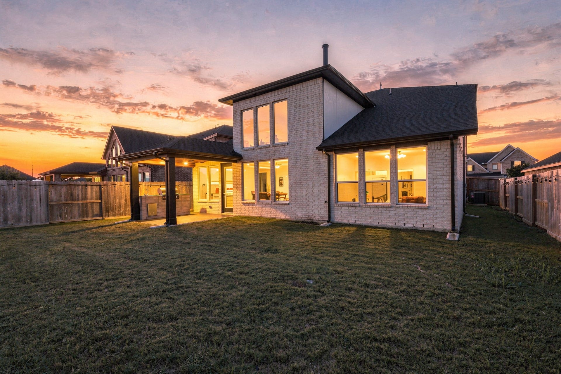 31539 Beacon Cove Trail, Fulshear, TX 77441 The rear elevation takes on a warm glow at sunset as the covered patio opens to the backyard.