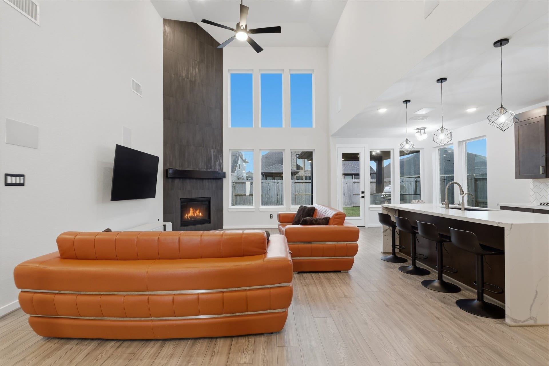 31539 Beacon Cove Trail, Fulshear, TX 77441 Soaring ceilings and a dramatic wall of windows give the family room impressive scale and natural light.