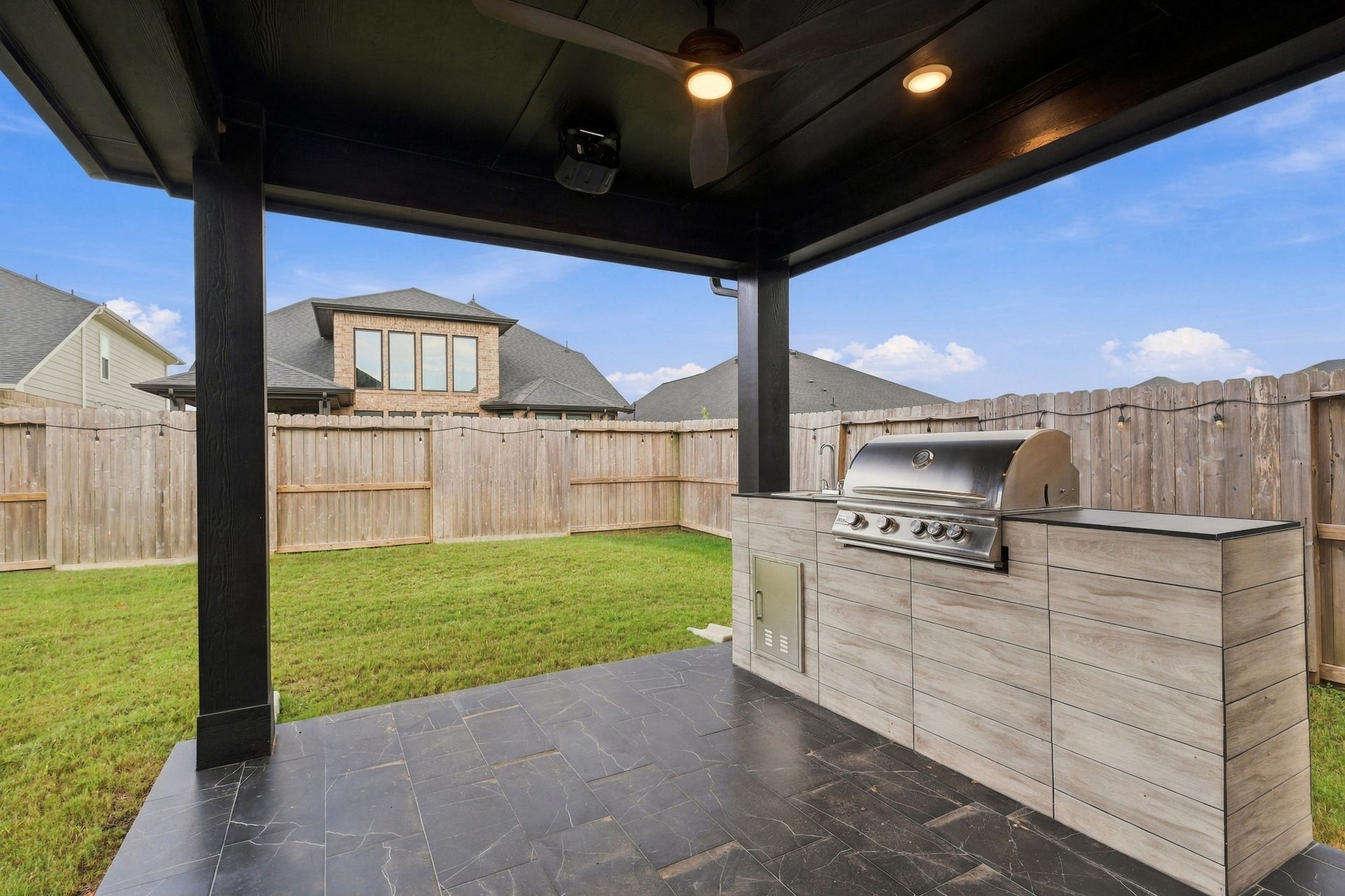 31539 Beacon Cove Trail, Fulshear, TX 77441 Recessed lighting and tile flooring enhance the covered patio and extend the homes entertaining space outdoors.
