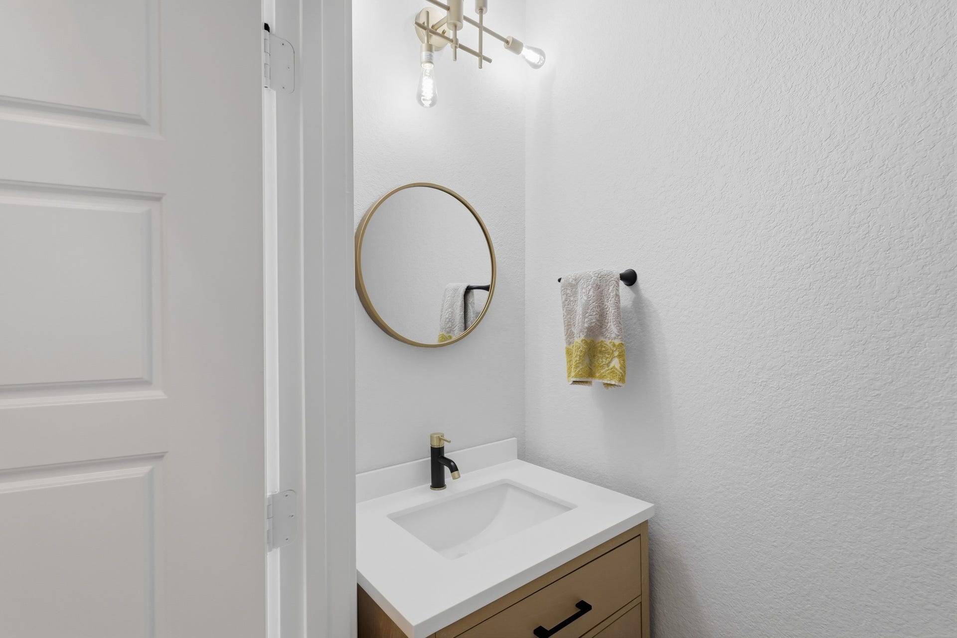 31539 Beacon Cove Trail, Fulshear, TX 77441 The first-floor powder room continues the modern aesthetic with a streamlined vanity and statement mirror.