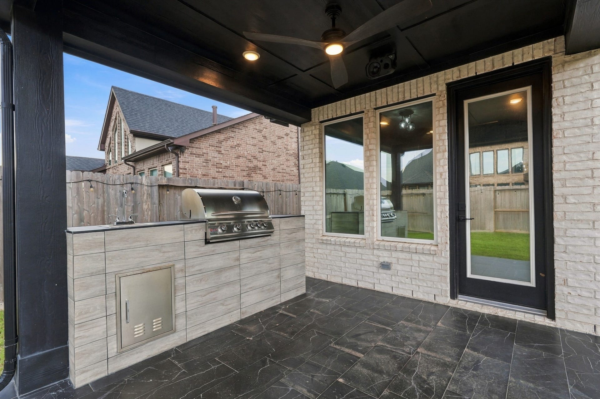 31539 Beacon Cove Trail, Fulshear, TX 77441 The outdoor kitchen features tiled surfaces, dedicated prep space and a high-end built-in grill for effortless outdoor entertaining.