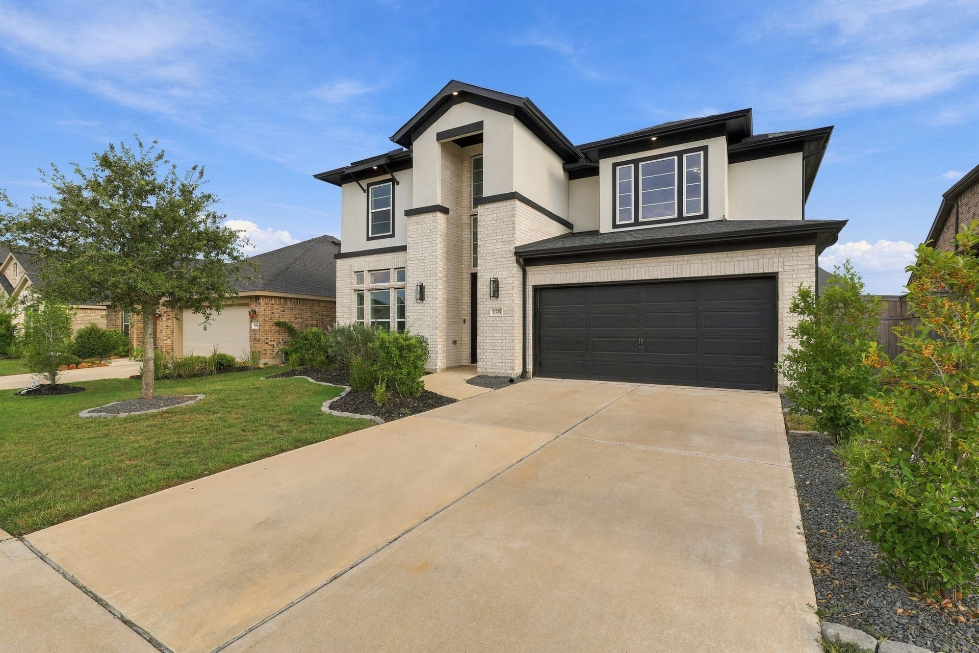 31539 Beacon Cove Trail, Fulshear, TX 77441 Expanded driveway with attached two-car garage, offering ample parking and easy access.