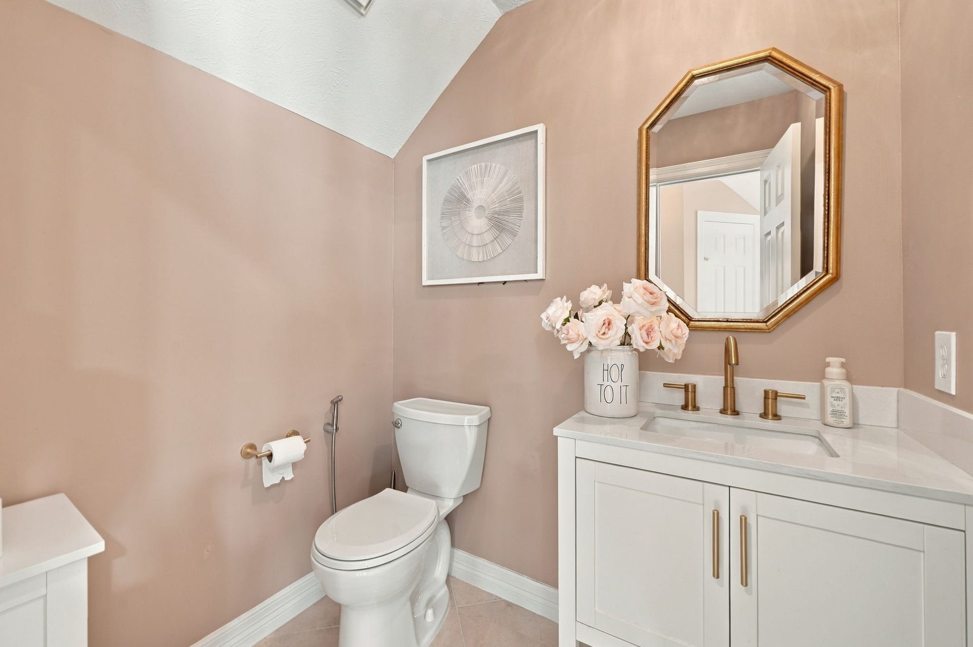 7610 Northwoods Drive, Sugar Land, TX 77479 A charming powder room with soft blush tones and elegant gold accents adds a sophisticated touch for everyone.
